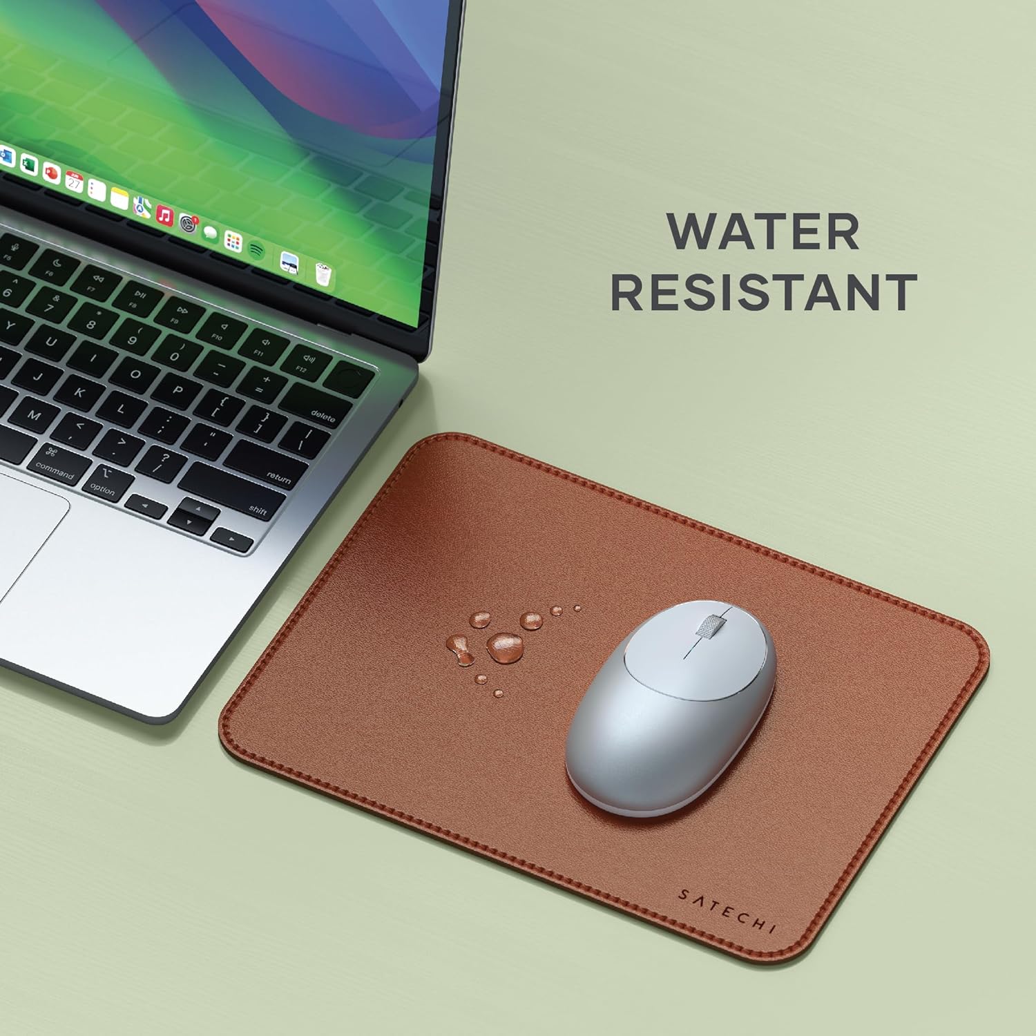 Water droplets on the Satechi Vegan-Leather Mouse Pad next to a laptop, illustrating its water-resistant feature