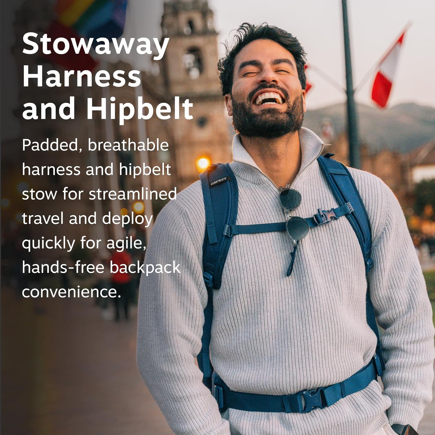 A person smiling while wearing the Osprey Farpoint backpack, illustrating the comfort of the stowaway harness and hipbelt.