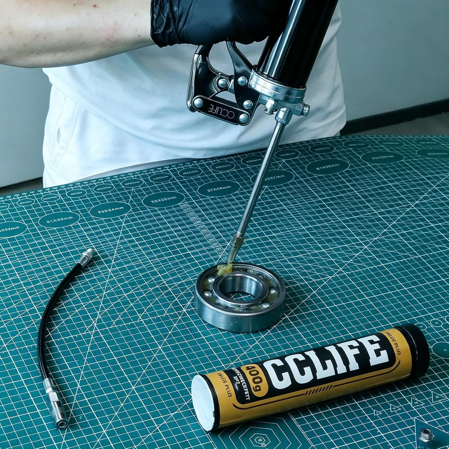 Person applying grease to a bearing with the grease gun