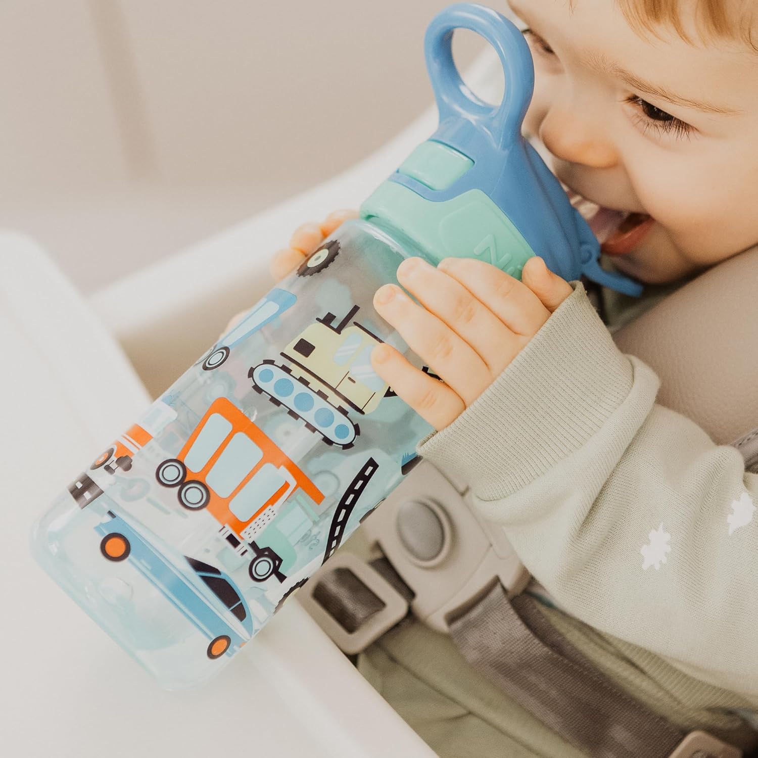 A child drinking from a Nuby Super Quench water bottle.