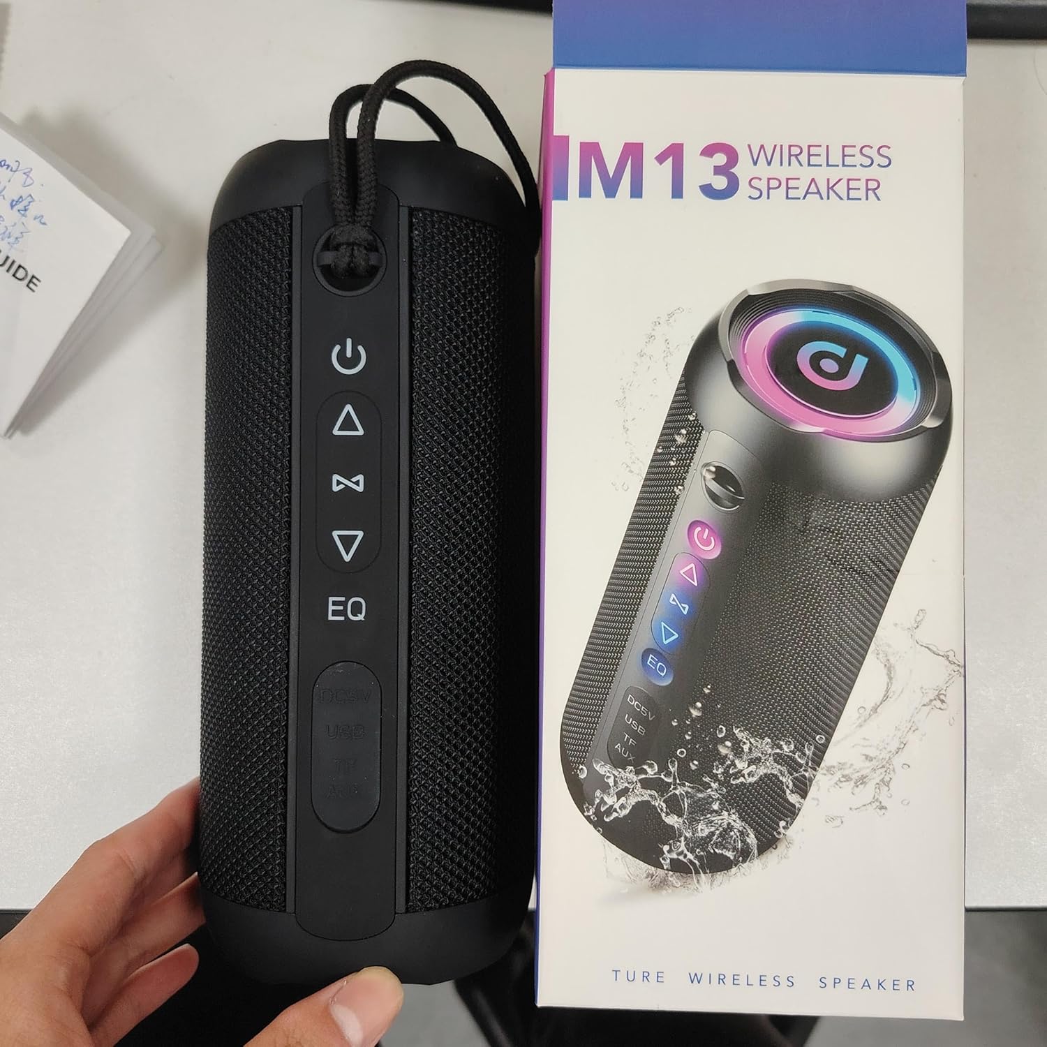 taopodo M13-BK speaker next to its retail packaging, showing the included quick start guide.
