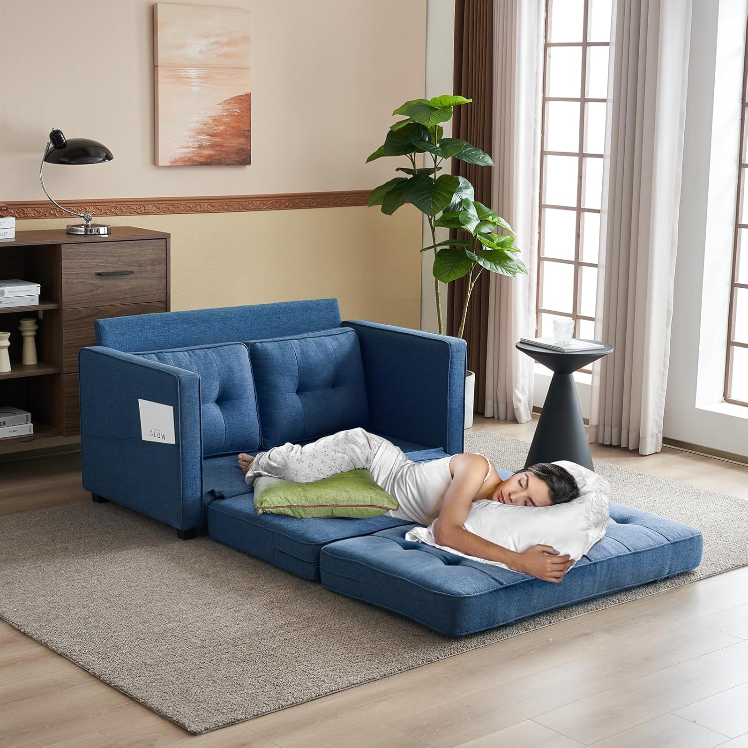 Person sleeping on the VINGLI Loveseat Sleeper in its fully extended bed configuration.