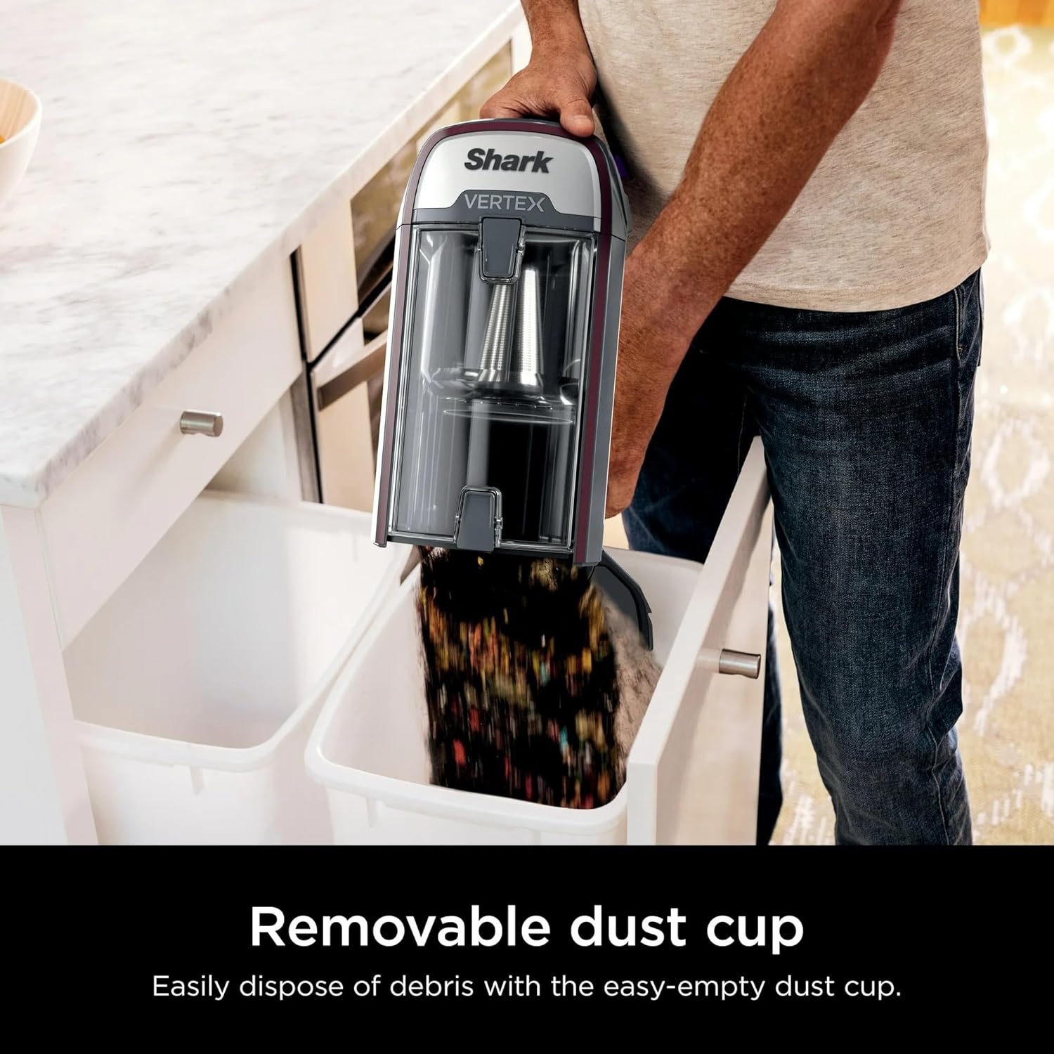 Man emptying the removable dust cup into a trash bin