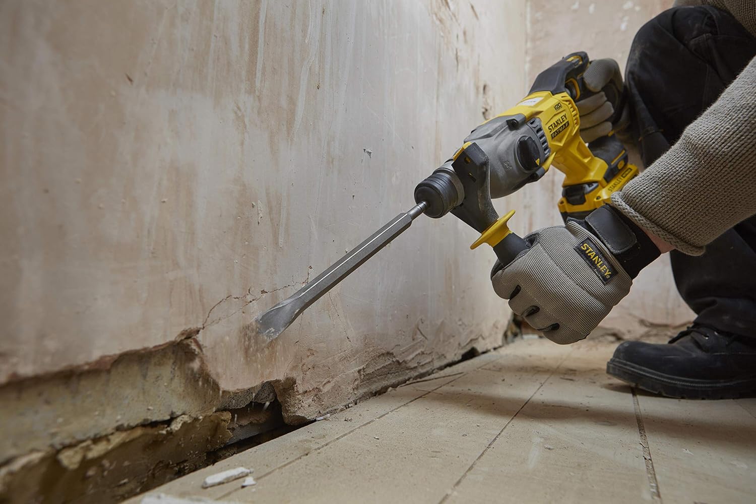 Person using the hammer drill in chiseling mode on a wall