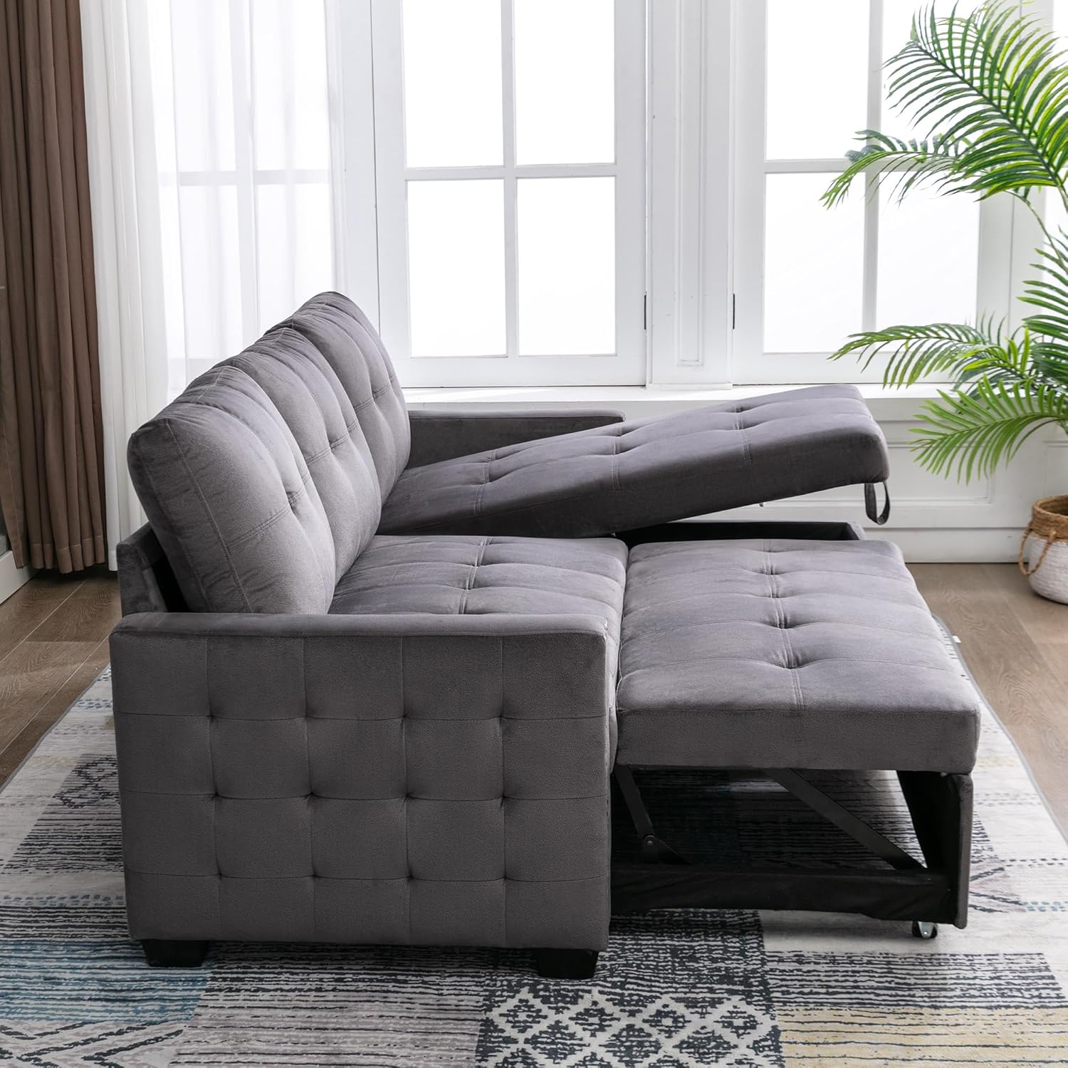 Aldea view of the Polibi sectional sofa, showing the pull-out sleeper mechanism partially extended from beneath the main seating area.