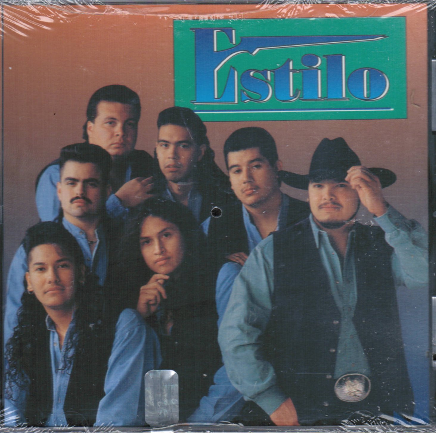 Album cover for Estilo Audio CD, featuring a group of seven men, likely the band members, in a studio setting. The band name 'Estilo' is prominently displayed at the top right.