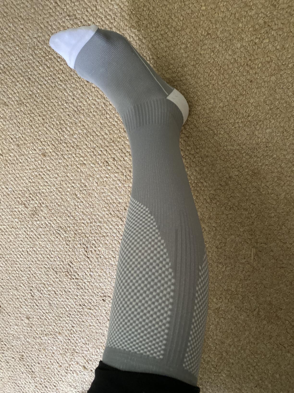 Three pairs of Solunara compression socks folded in a plain cardboard box