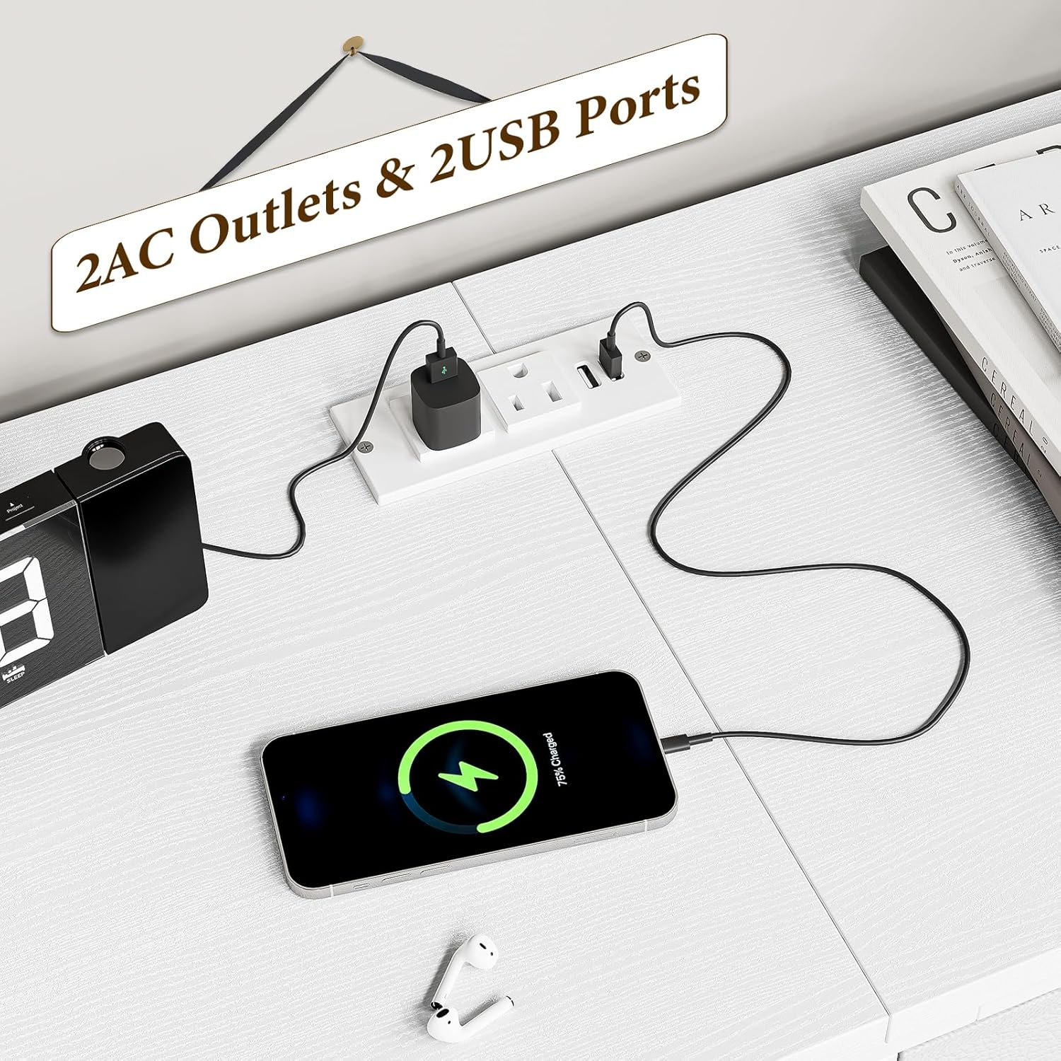 Close-up of the integrated power strip on the Patikuin dresser TV stand, showing 2 AC outlets and 2 USB ports in use with a phone and clock.