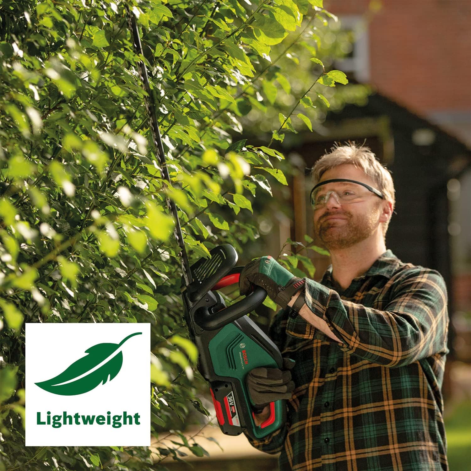 User trimming a hedge with the lightweight Bosch hedge trimmer