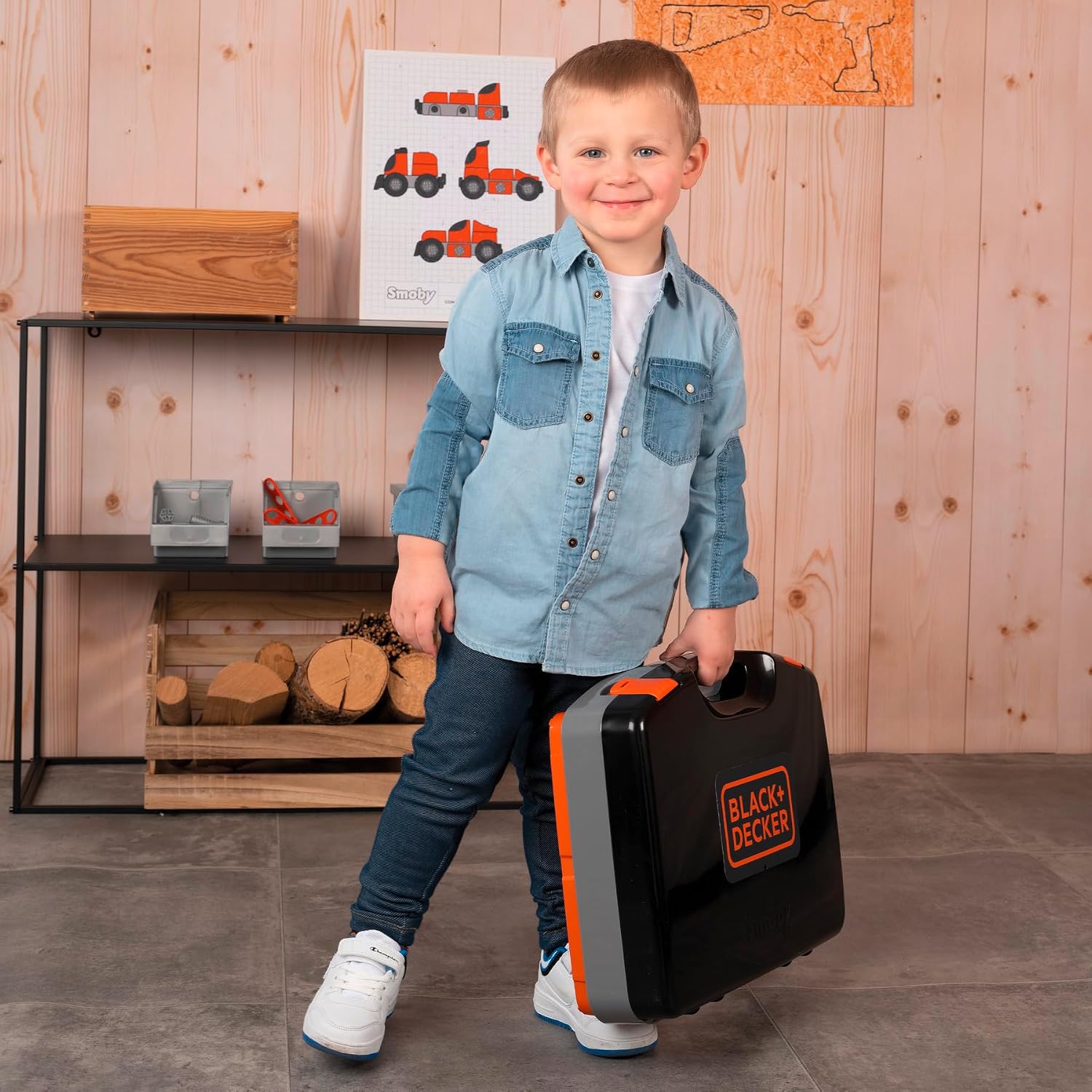 Child holding the Smoby Black+Decker Bricolo Smart Workbench in its compact case form