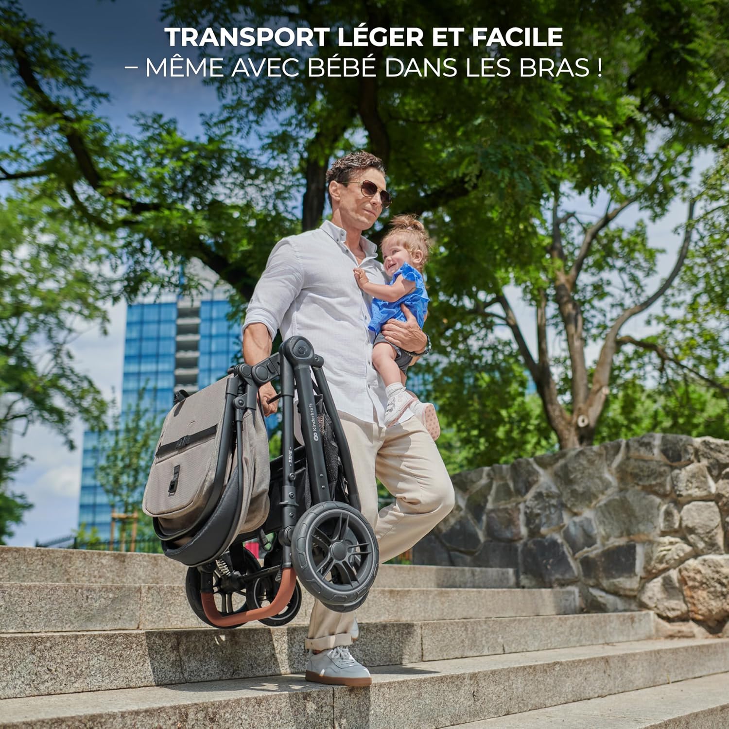 Adult carrying a folded ESME stroller and a baby, demonstrating its portability.