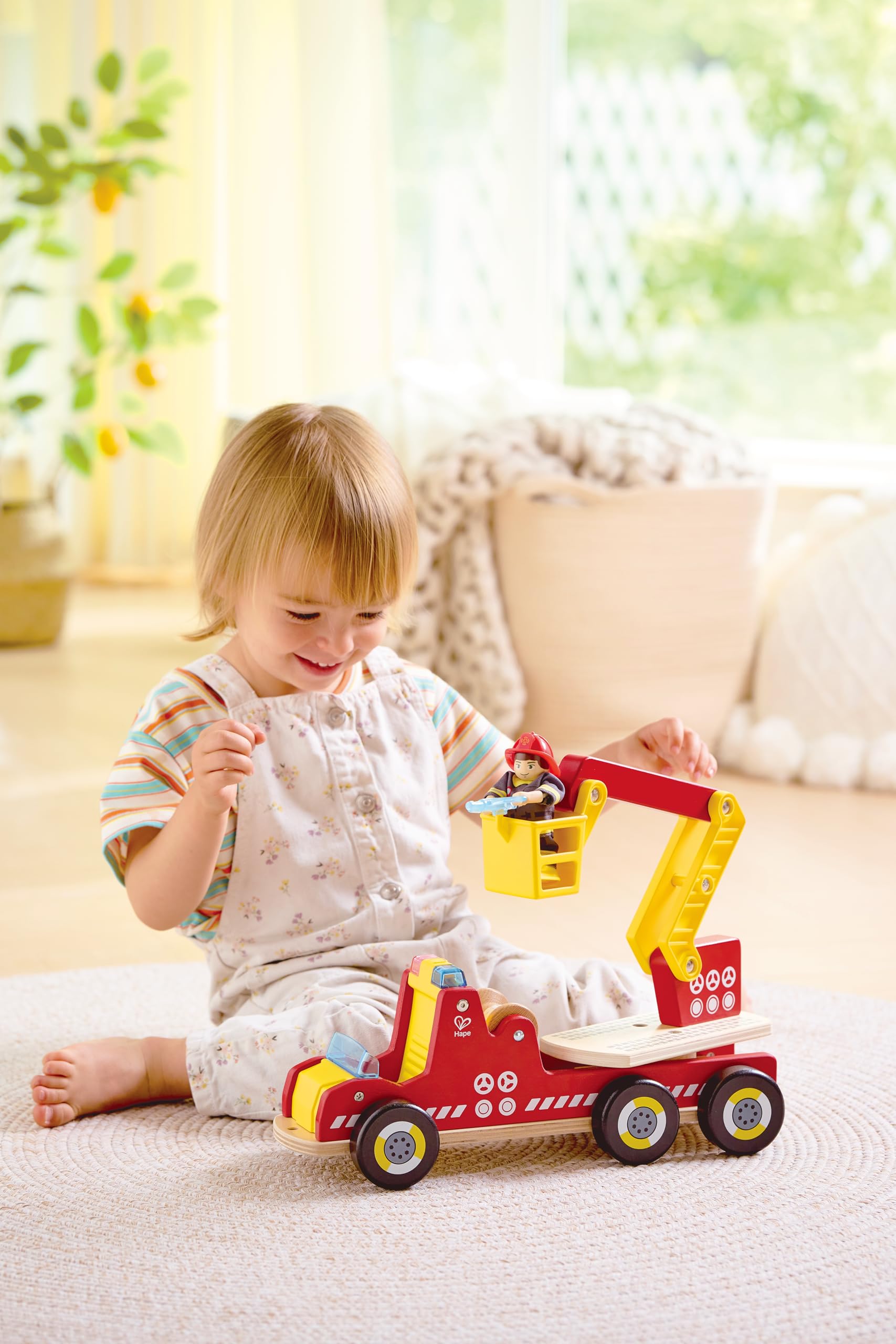Hape Feuerwehrauto mit Beleuchtung und Sirene - mit Feuerwehrmann-Figur, Spielzeugauto, Feuerwehrauto mit drehbarer Leiter & Zubehör, aus Holz, Rollenspielzeug für Kinder ab 2 Jahren