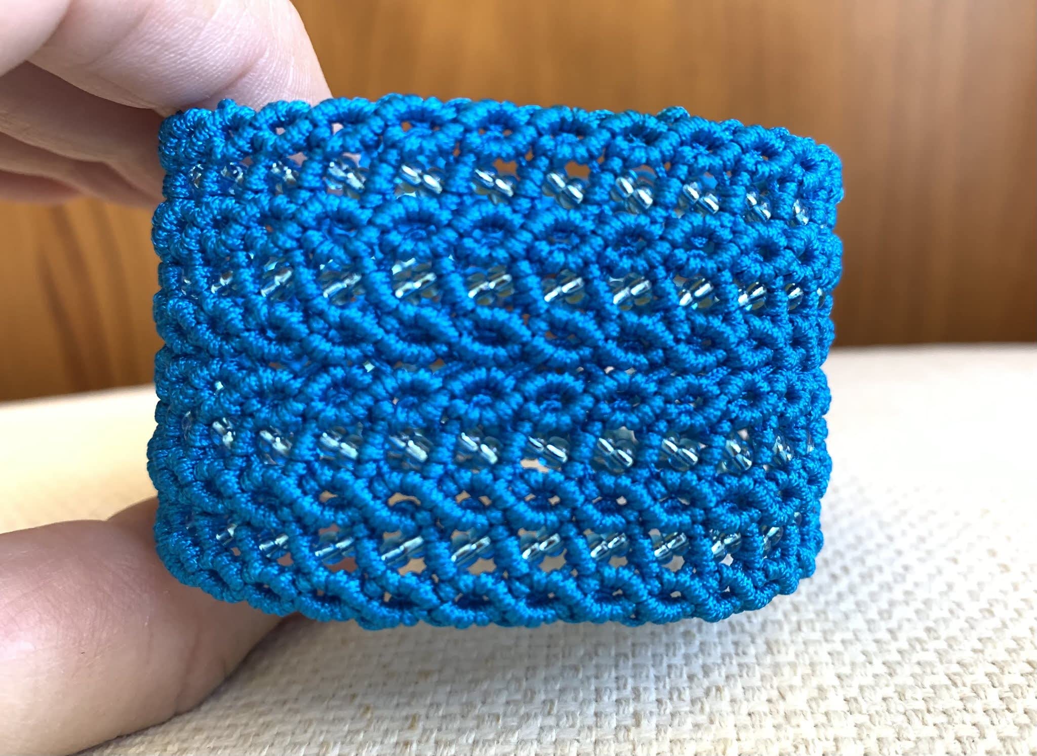 Pulsera macramé ancha azul hecha a mano con pequeñas rocallas cristal a juego Mide aprox.17,5 cm. de largo y 4 cm. de ancho.Cierra con dos botones