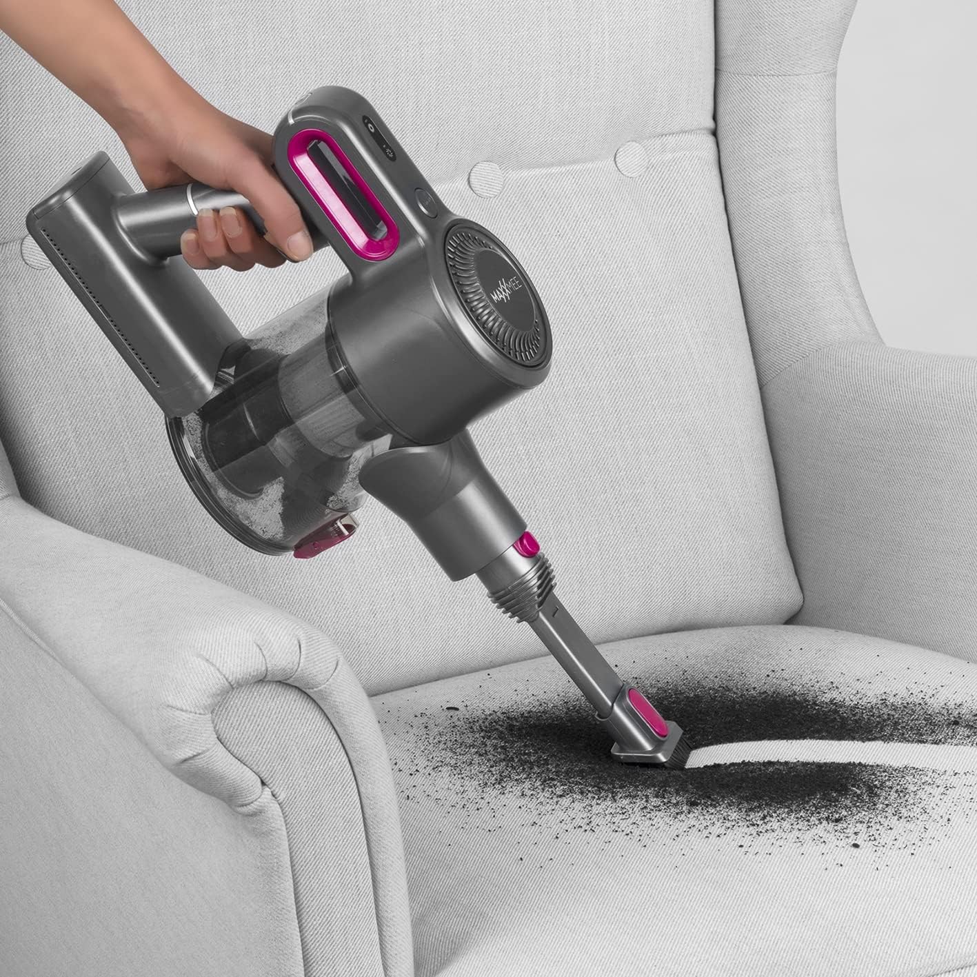 User cleaning armchair with MAXXMEE 02026 handheld vacuum