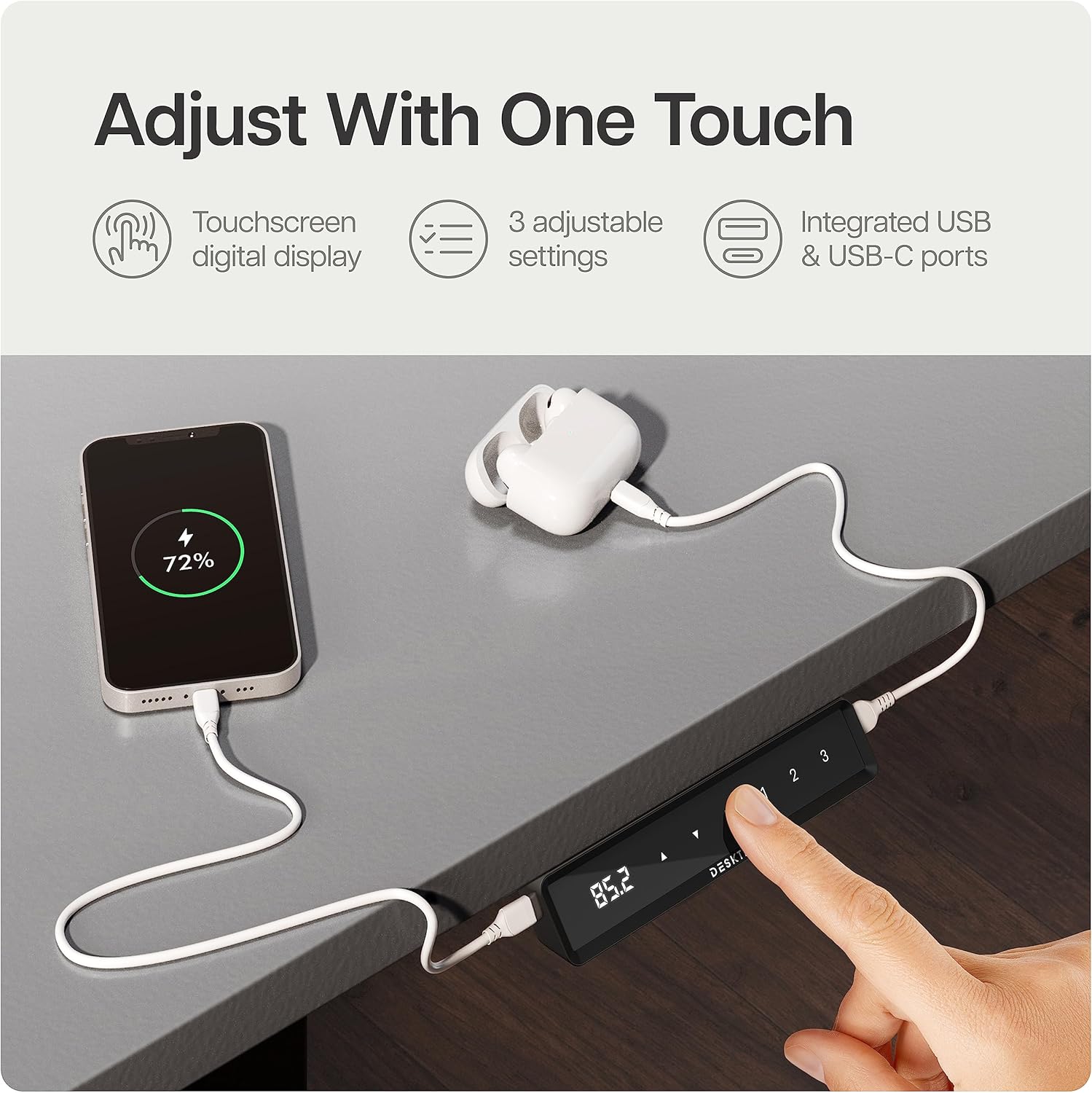Close-up of the Desktronic desk's touchscreen control panel with USB and USB-C ports, showing a phone charging.