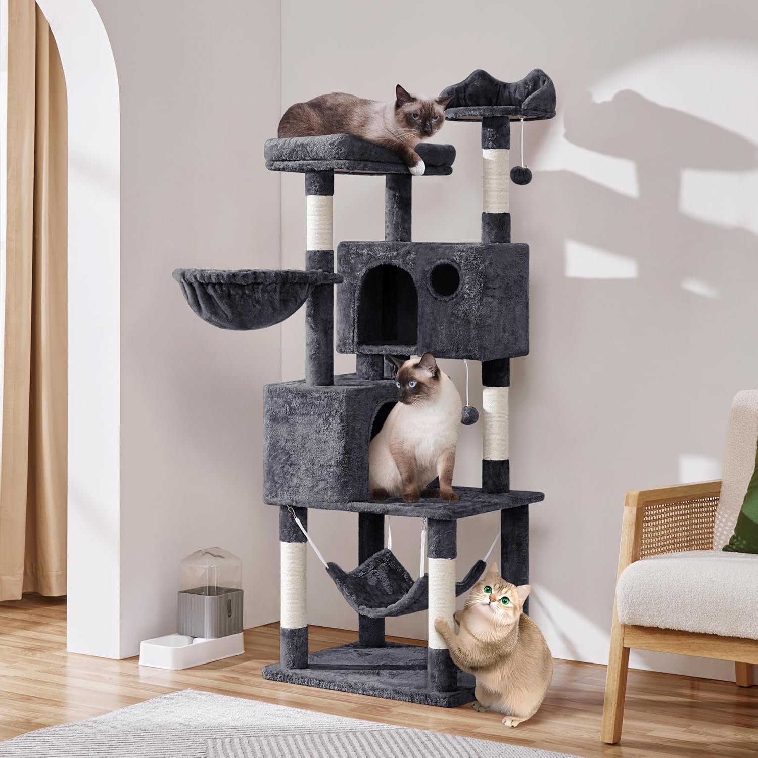 A cat resting inside one of the cozy condos of the cat tree.