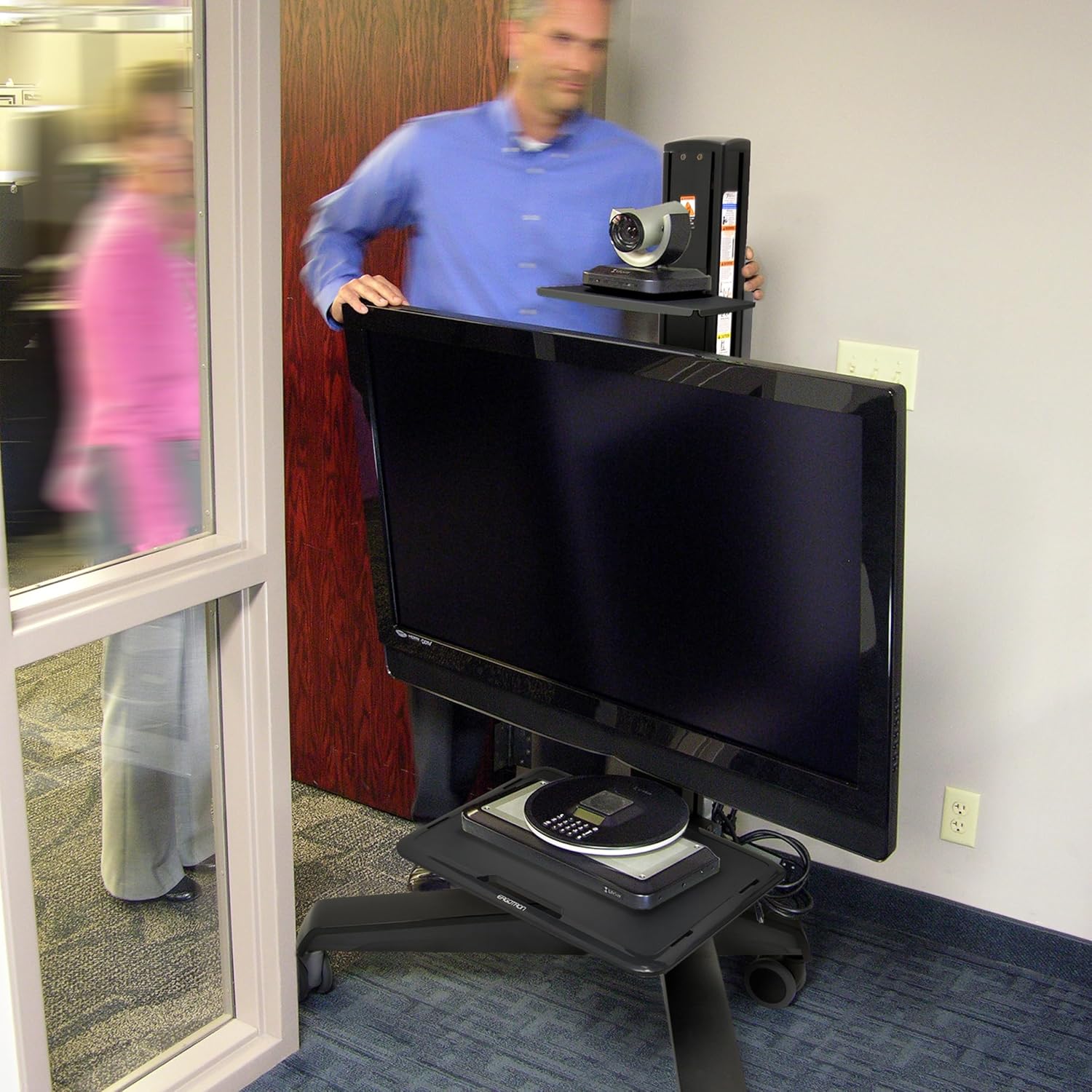 Person moving the Ergotron cart with a large monitor through a doorway