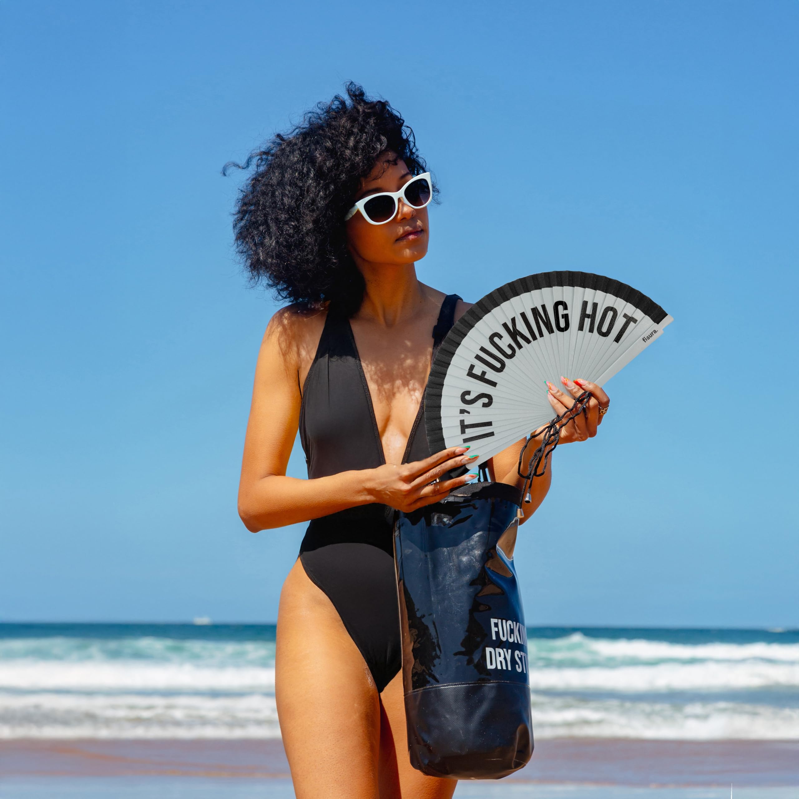 Fisura – Nowoczesny wachlarz z napisem "it’s f*cking hot”. Stylowy ręczny wentylator z drewna w odcieniach szarości i czerni. Zawieszka. Wymiary: 42,5 x 23 cm