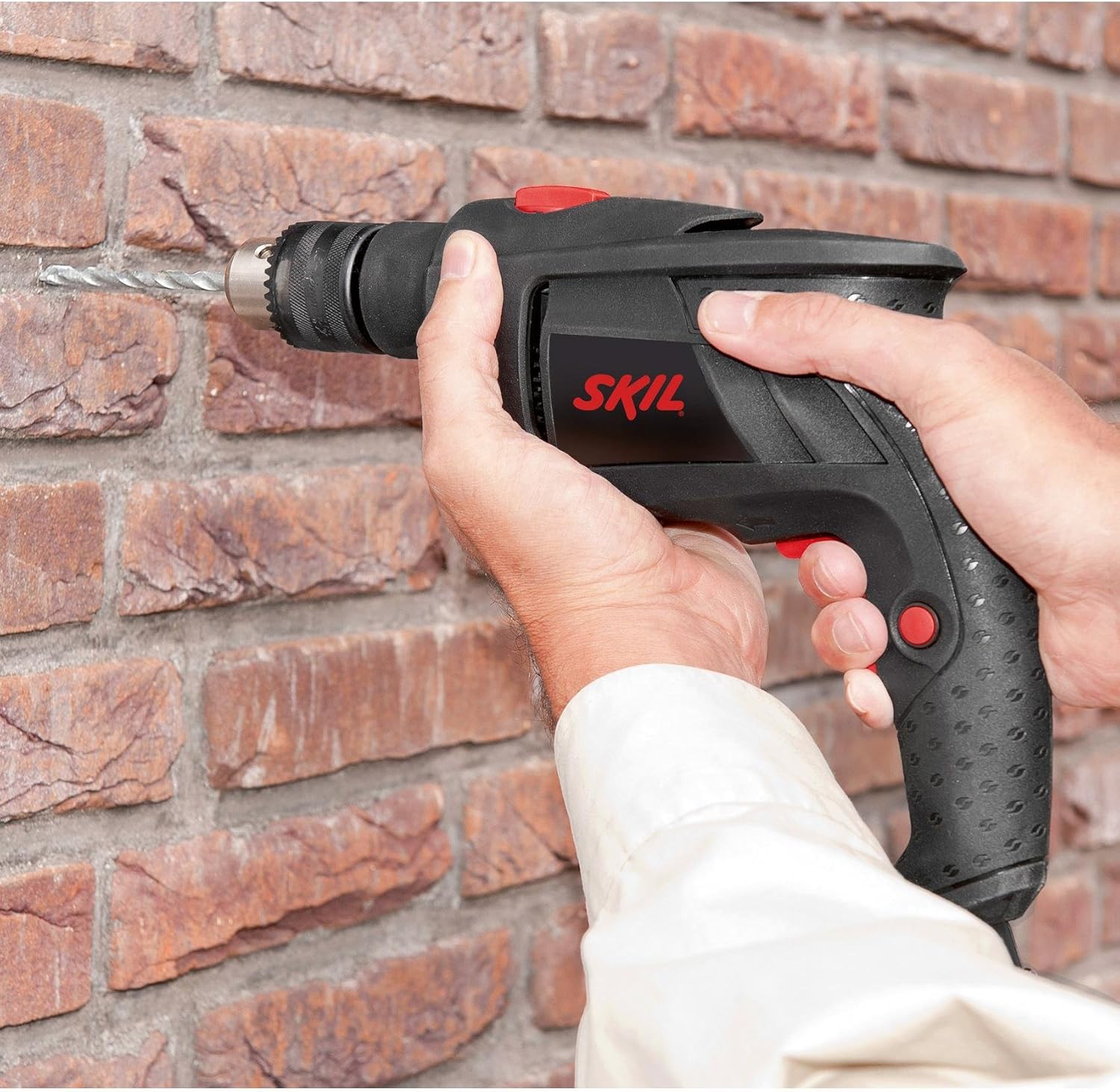 Person using SKIL 6002CA drill in impact mode to drill into a brick wall