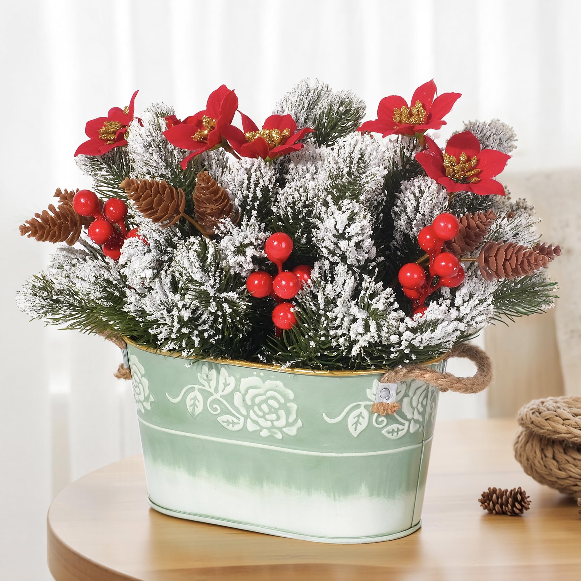 Centre de table de Noël avec pin Norfolk enneigé et poinsettias sous boîte métal