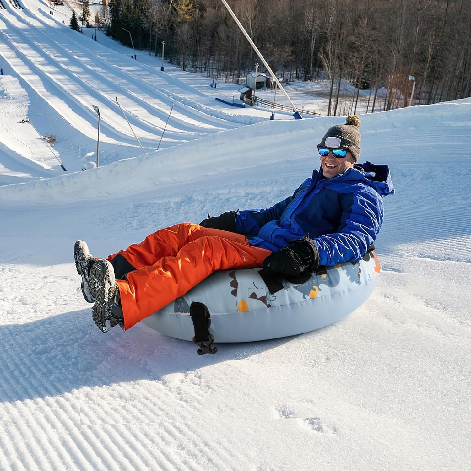 Person happily sledding down a snowy hill on the DORTALA snow tube