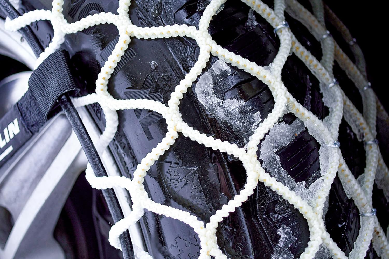 Close-up of MICHELIN Easy Grip Limited snow chain textile mesh on a tire