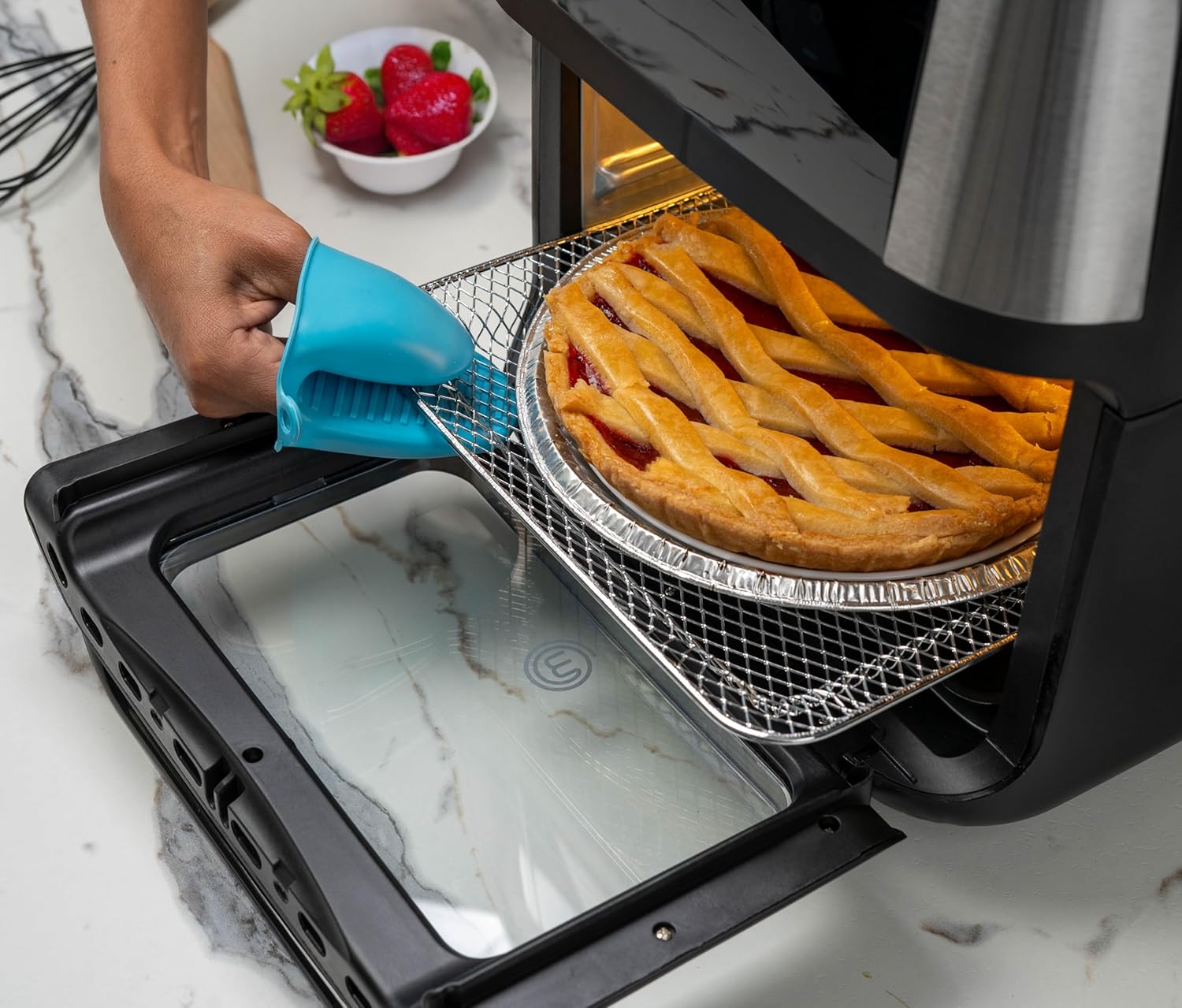Hand removing a rack with cooked food from the air fryer oven.