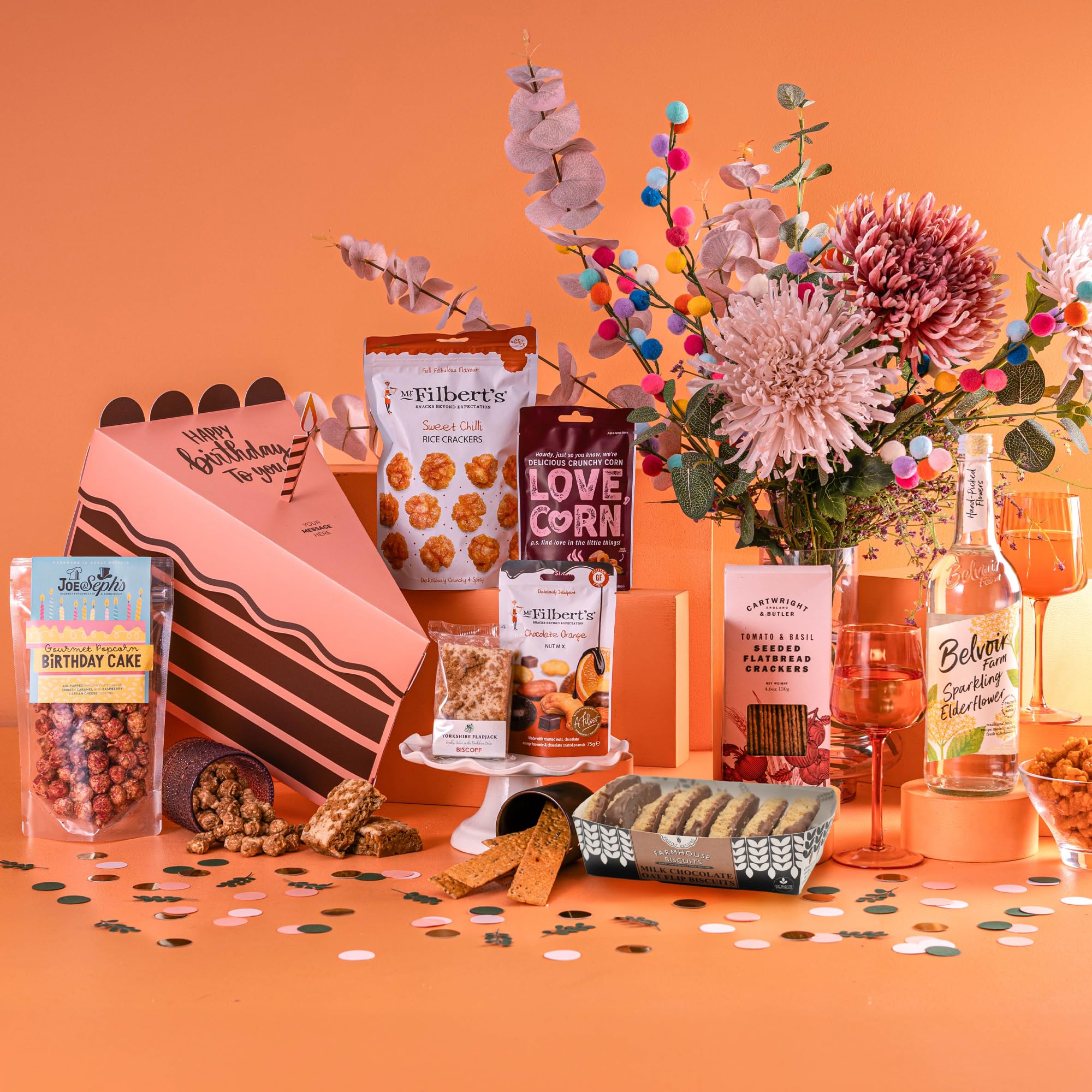 Kosz na prezent urodzinowy "A Slice of Paradise" – pudełko w kształcie kawałka ciasta z popcornem Joe & Sepha, przekąskami Mochi i wyborem napojów, zestaw upominkowy urodzinowy, bez alkoholu