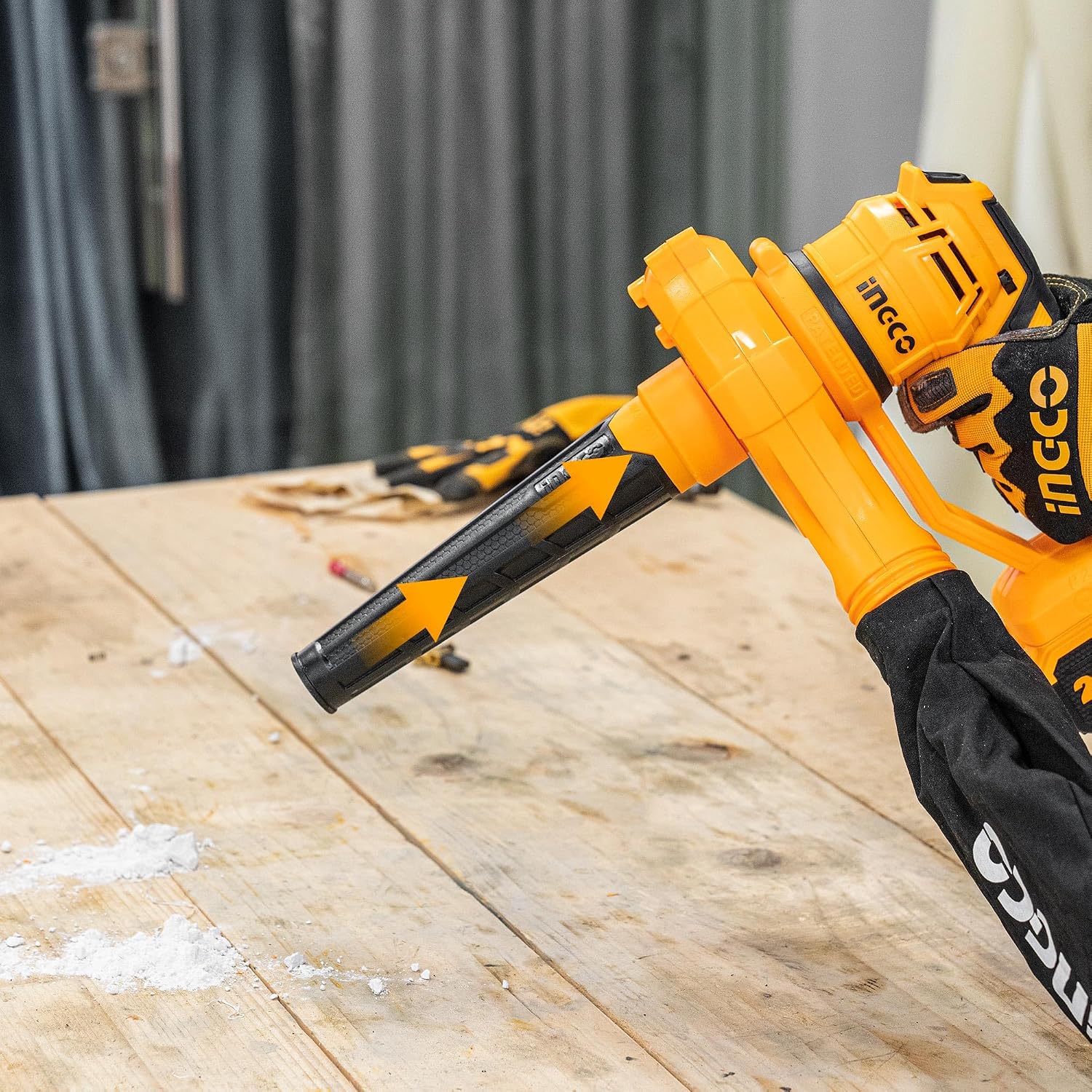 Blower clearing sawdust from a workbench