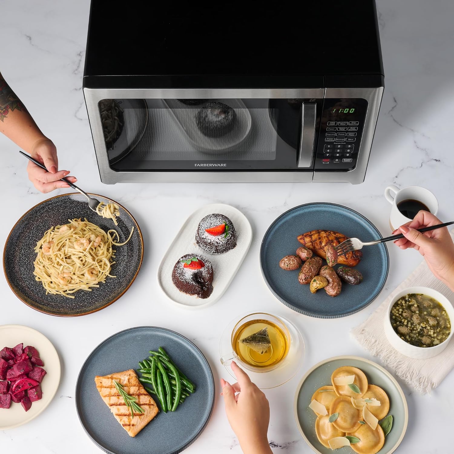 Various cooked dishes on a table with the Farberware Microwave in the background