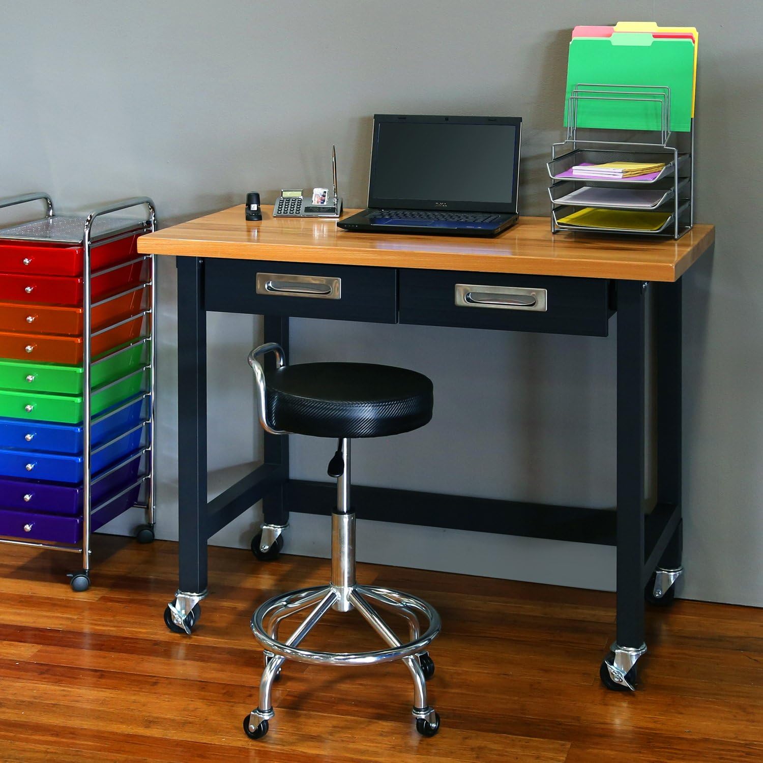 Workbench used as an office desk with a laptop and office supplies.