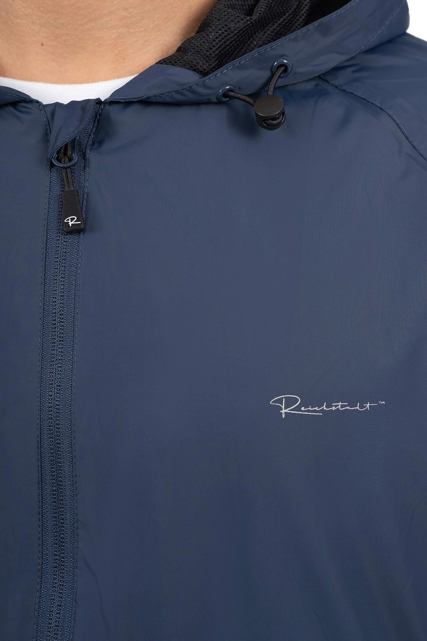 Reichstadt Chaqueta Impermeable Hombre Cortaviento Capucha Ligera Plegable | 100% impermeable, tejido transpirable, ligera, bolsa incluida, exterior, ciclismo, viajes, deporte, paseo y uso diario