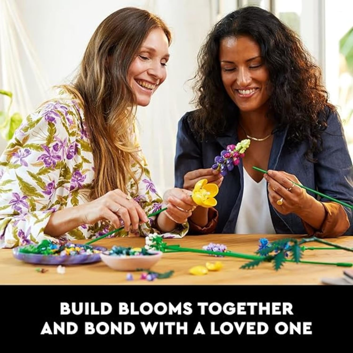 Two individuals smiling and assembling flower pieces from the building kit, demonstrating collaborative building.