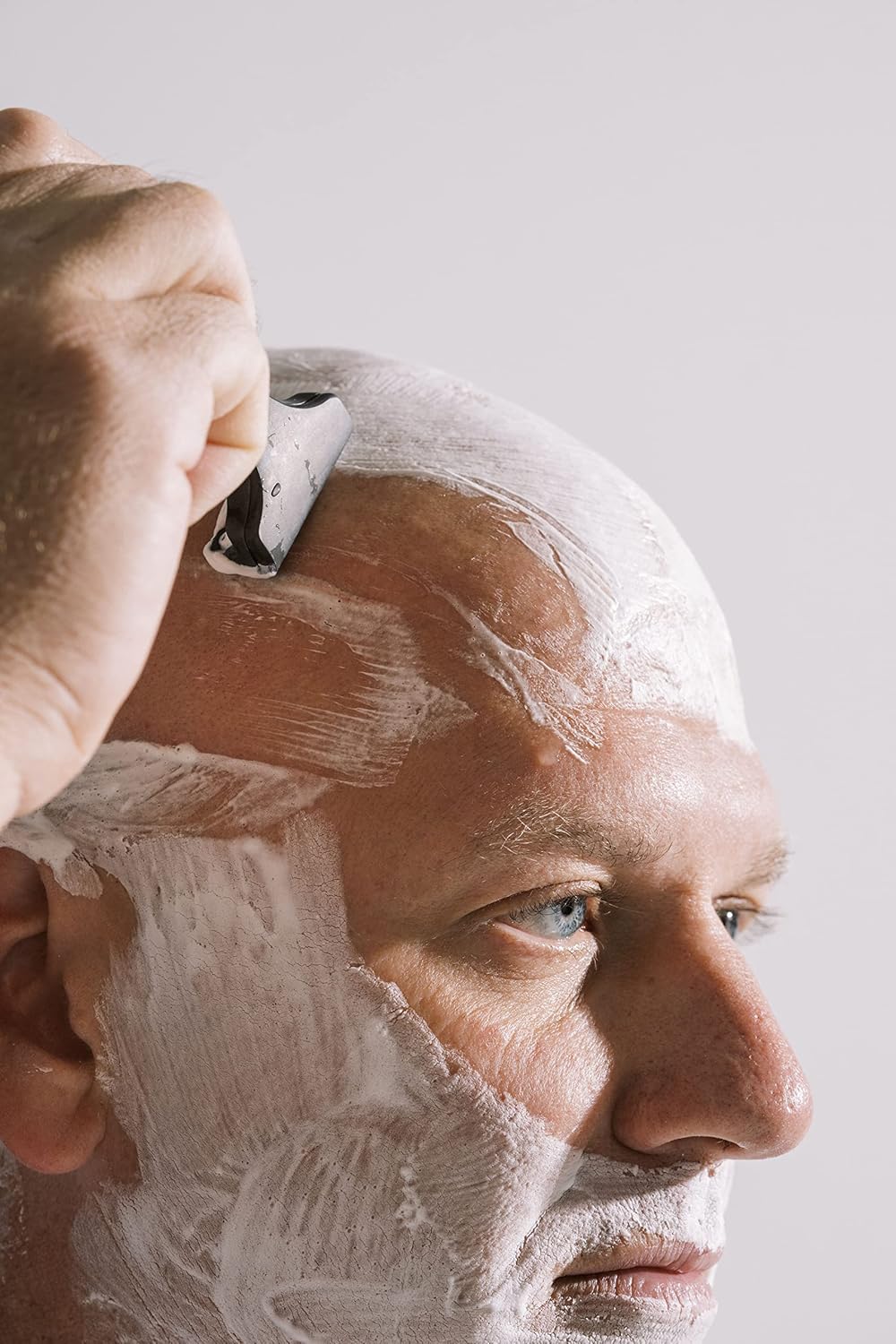 Person shaving head with Supply SE Razor