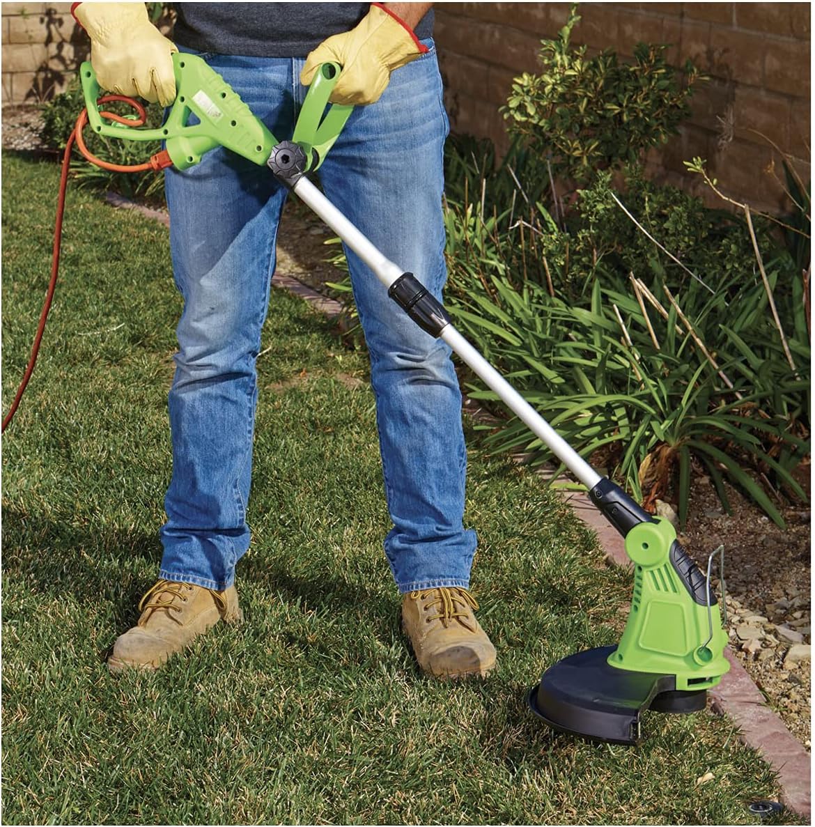 Person using the string trimmer to cut grass