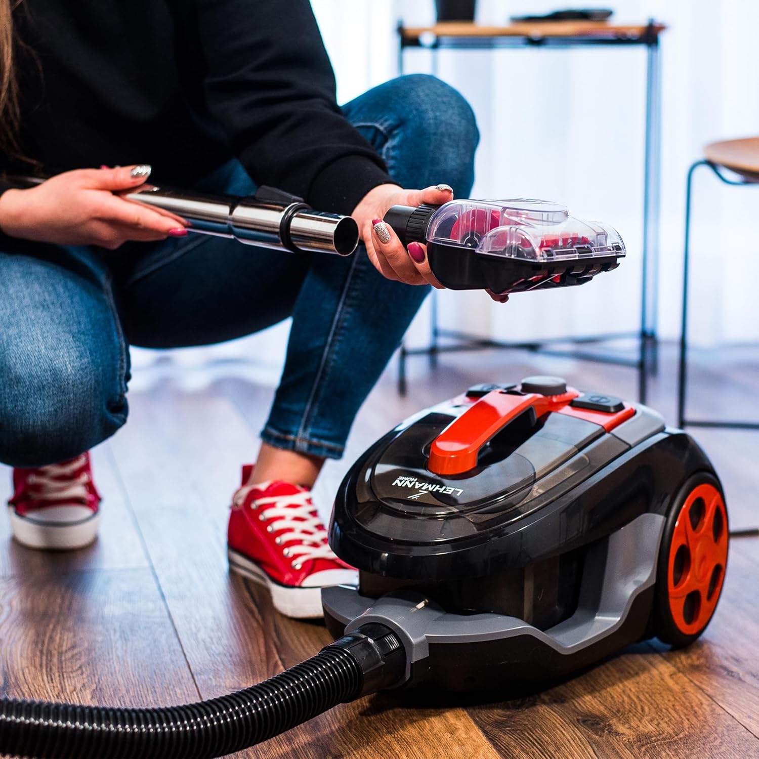 Person attaching a nozzle to the vacuum cleaner's telescopic tube