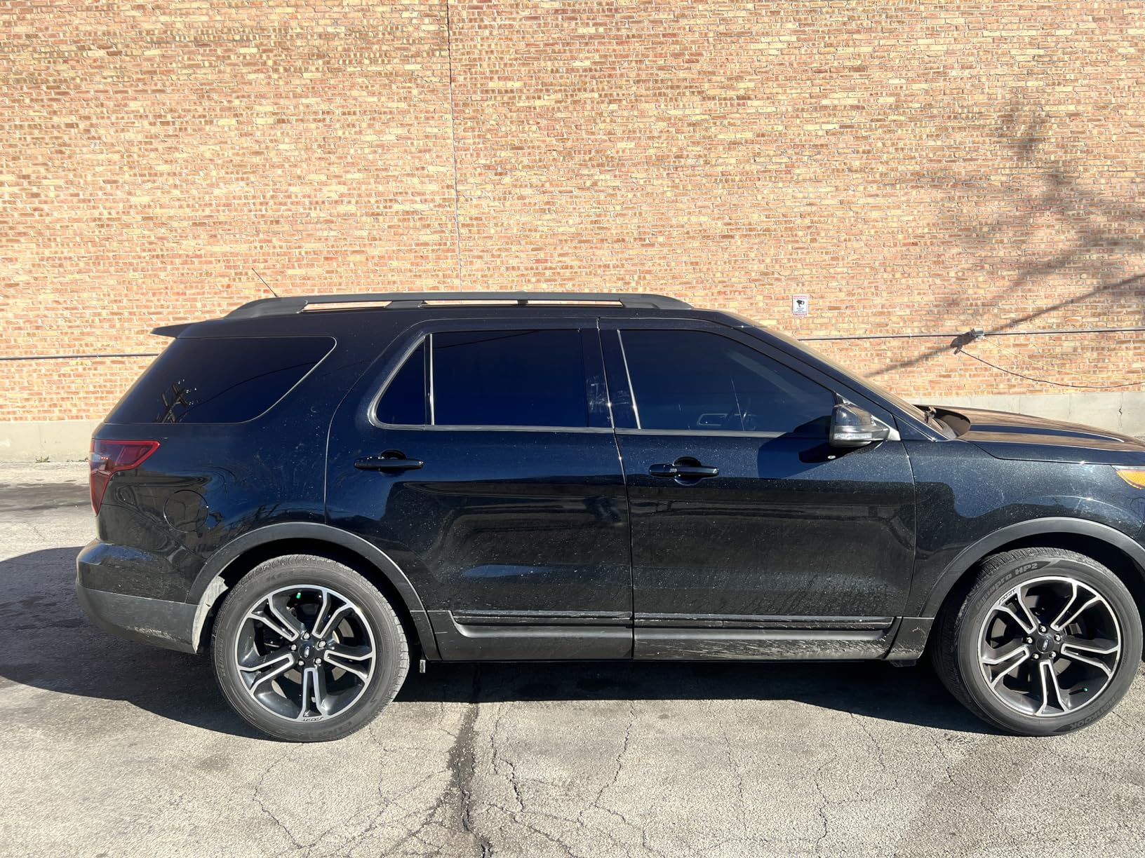 Close-up of a car door handle wrapped in gloss black vinyl