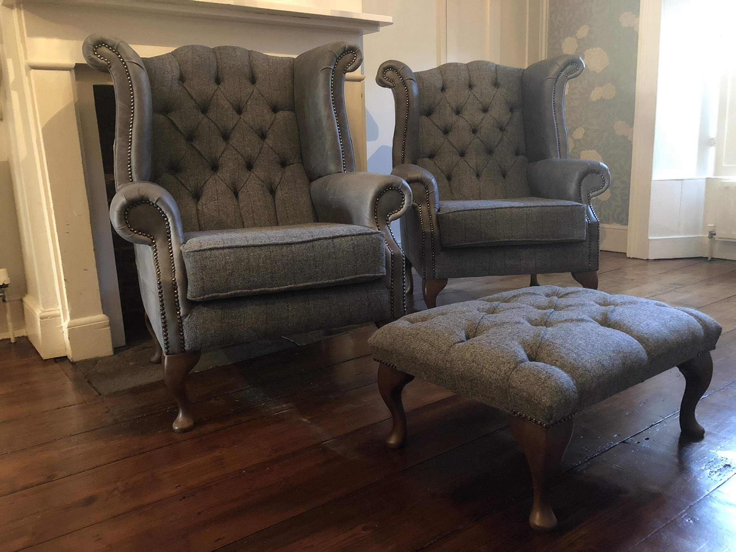 A pair of Chesterfield Queen Anne high back wing chairs and foot stool presented in vintage grey leather and grey Harris tweed