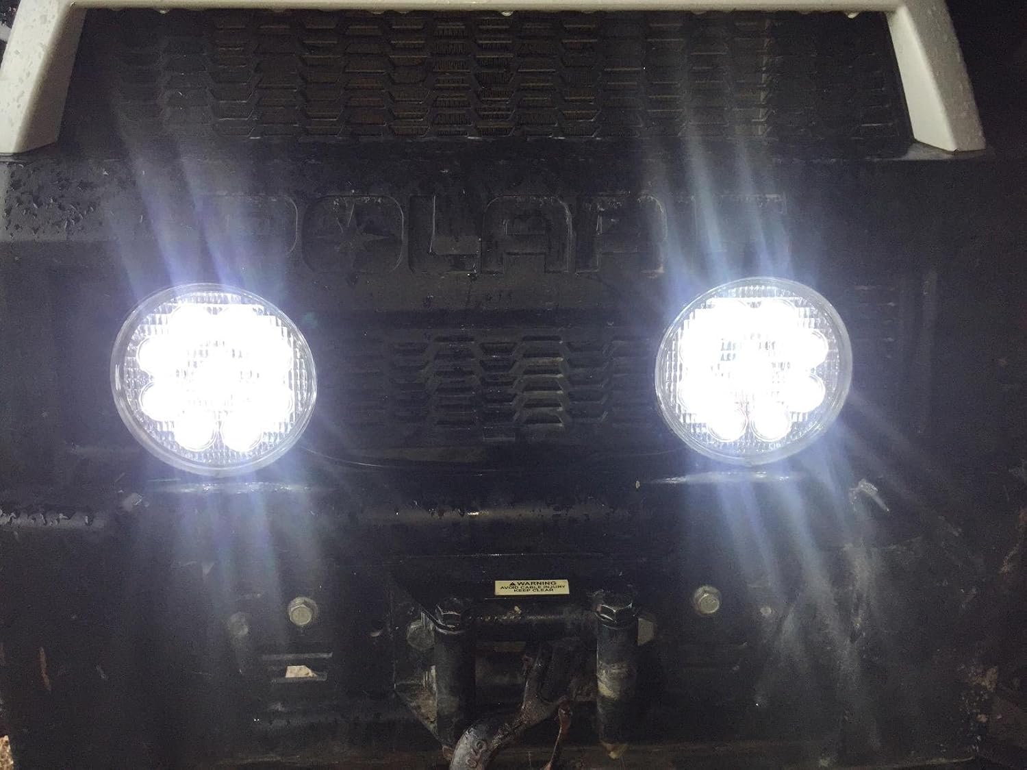 Two Willpower LED light pods installed on the front of a vehicle, illuminating brightly.