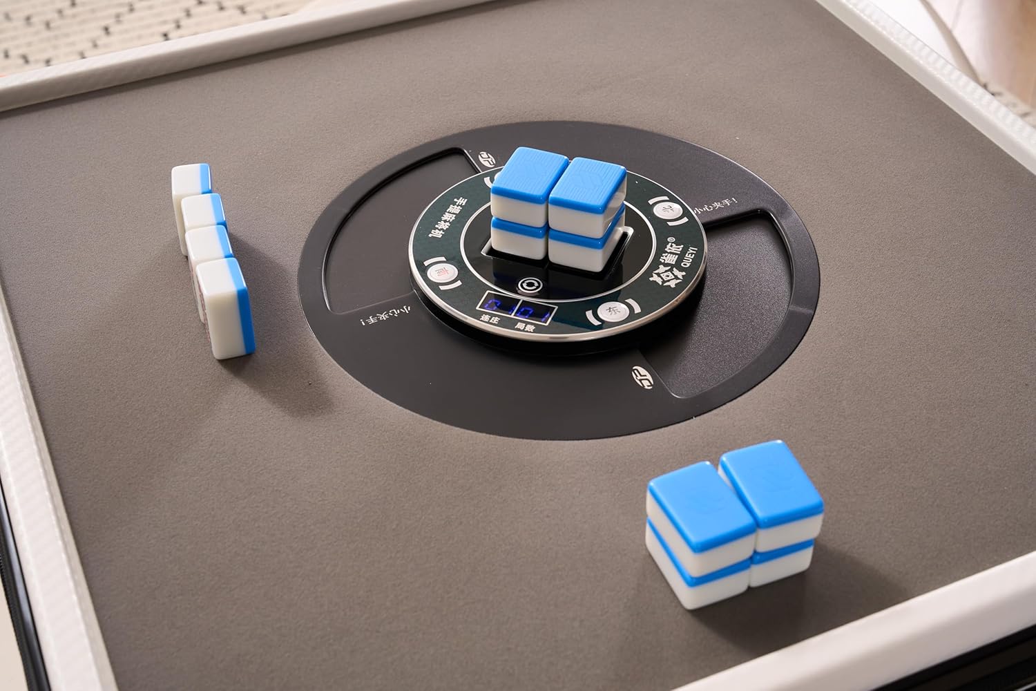 Close-up of the Yilezena Mahjong table's automatic shuffling mechanism with tiles being processed.
