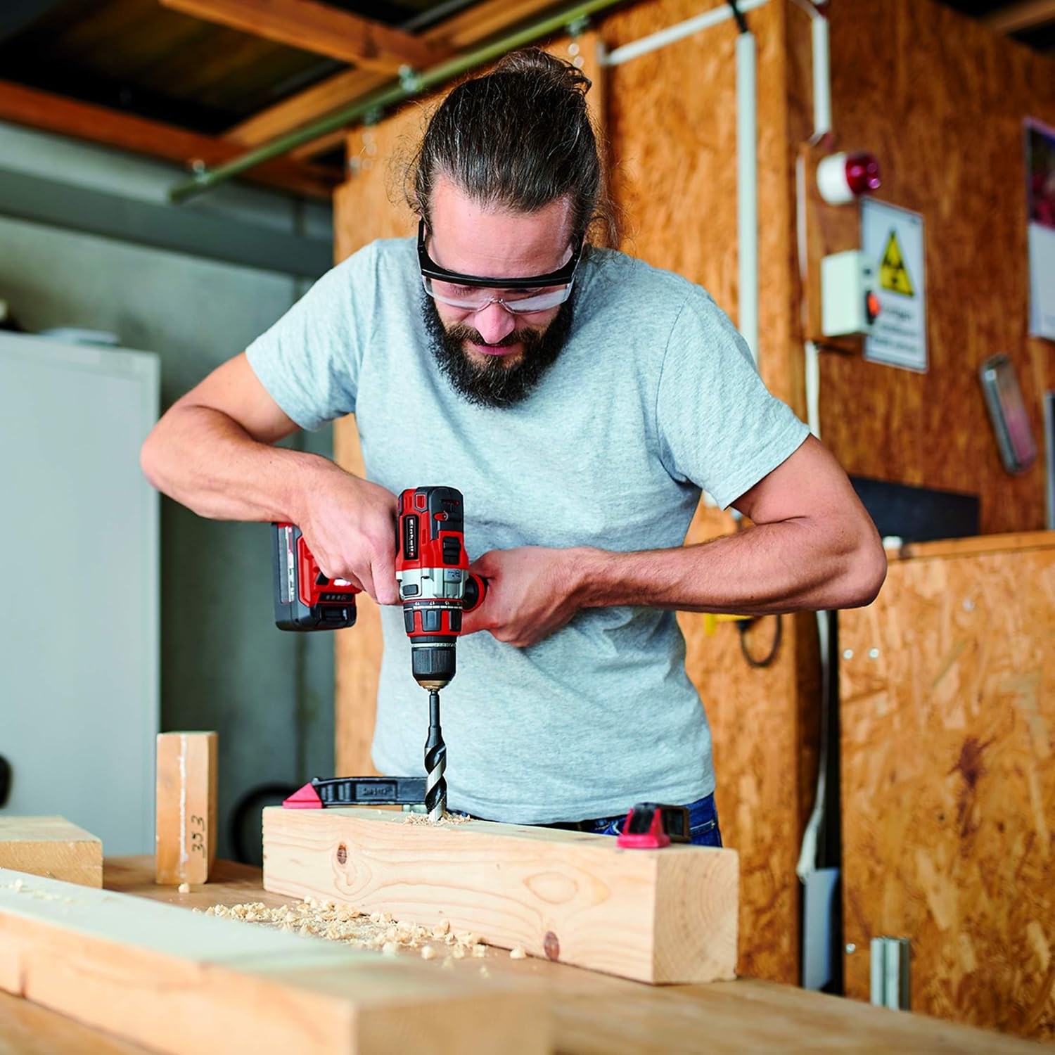 บุคคลกำลังใช้สว่าน Einhell เจาะไม้