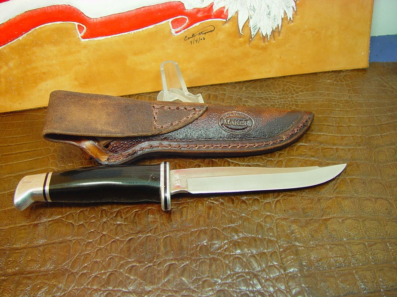 Vertical left-hand sheath for the buck 105 knife. The sheath is made out of 8 ounce leather hand tooled with a feather. The sheath is for the buck 105 knife are the sprayed Golden Spike will fit this sheath also. This is a left hand carry sheath. Sheath only knife not included.