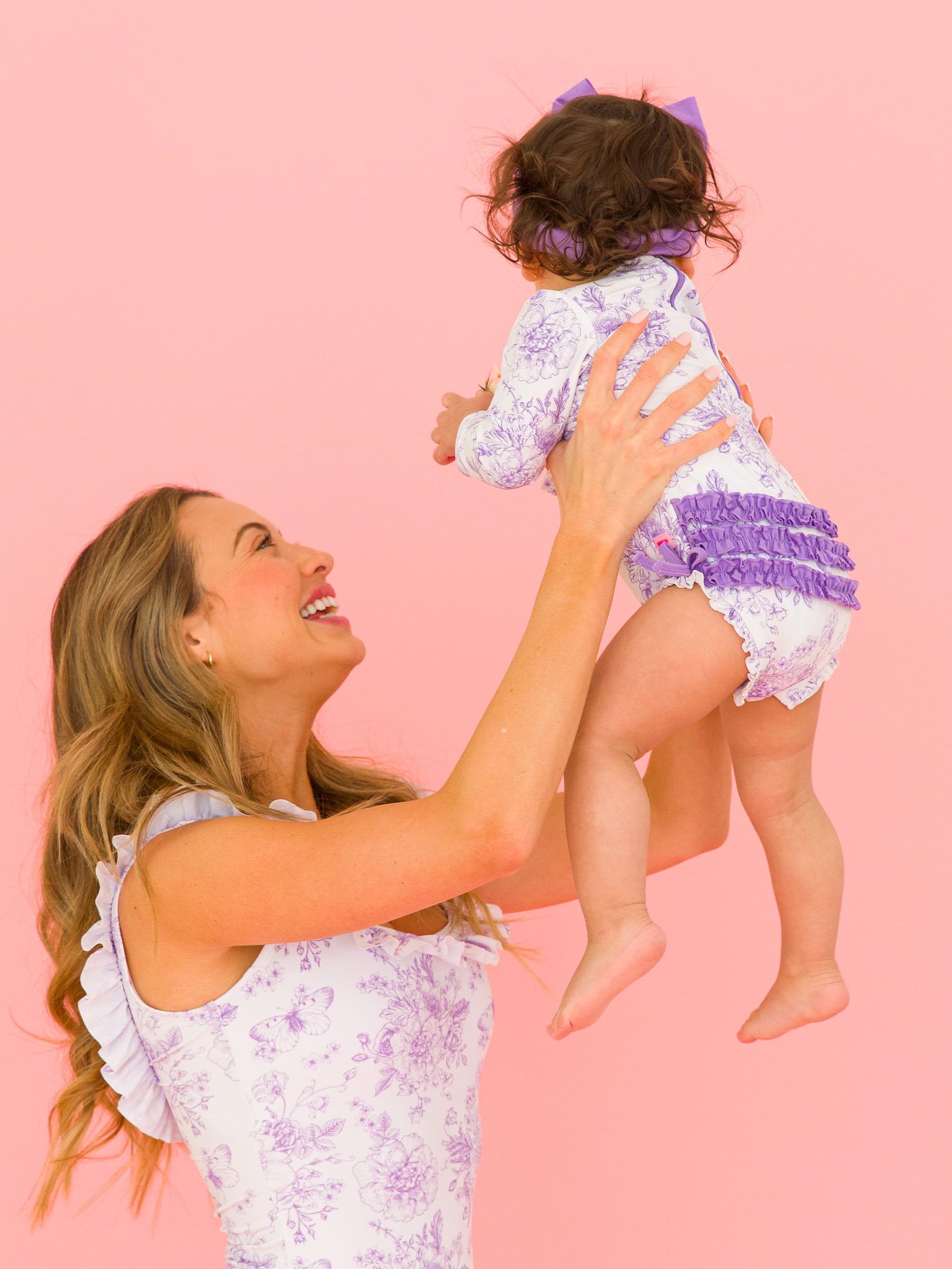 RuffleButts Costume da Bagno Intero A Maniche Lunghe con Stampa Floreale E Protezione Solare UPF 50 per Bambine, con Cerniera, Motivo Giardino di Farfalle Viola Glicine, 18-24 Mesi