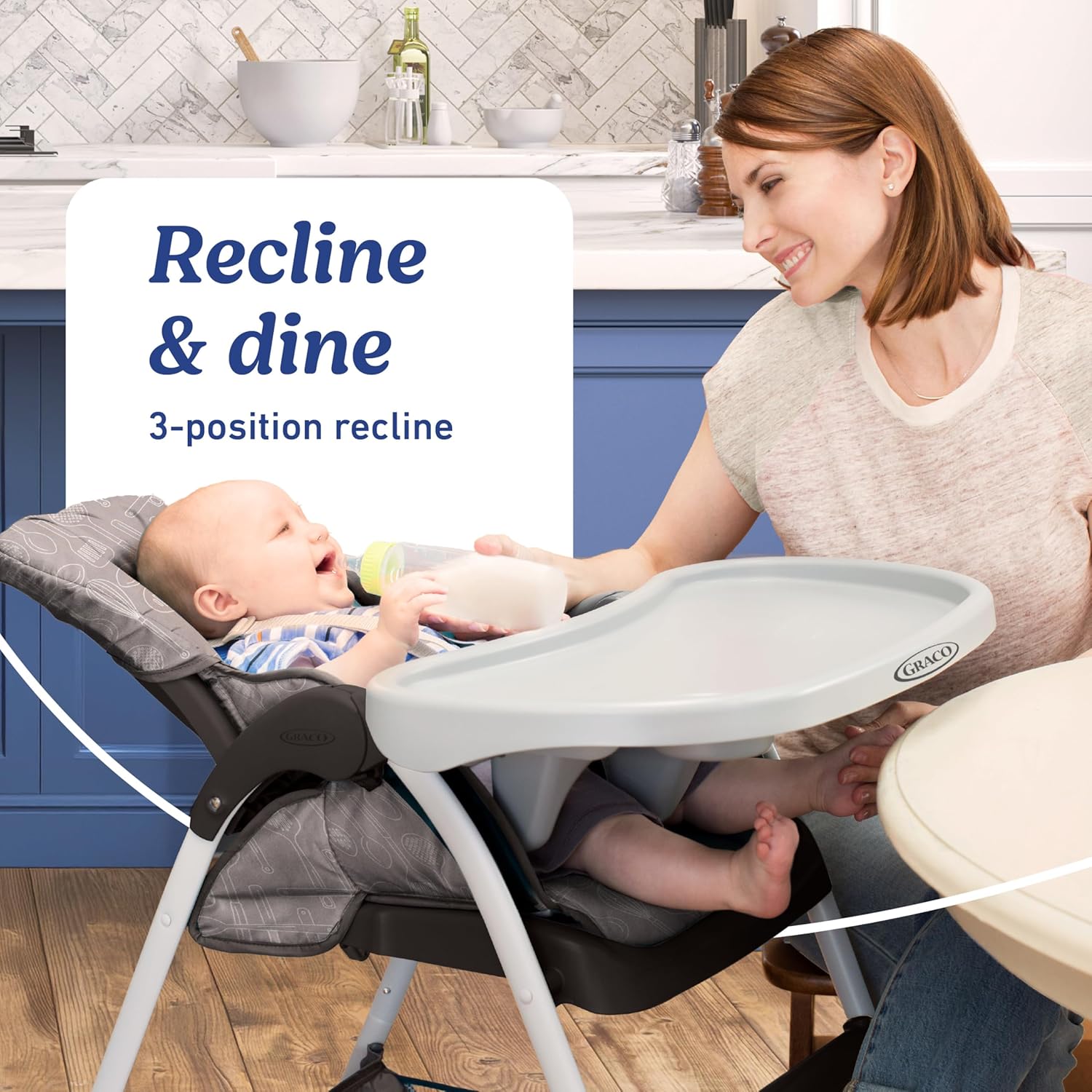 Baby reclining in the Graco Slim Snacker High Chair while being fed from a bottle.