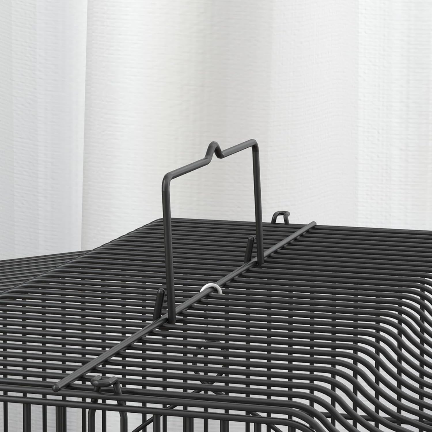 Close-up of a small door on the bird cage, open to show a feeder being inserted.