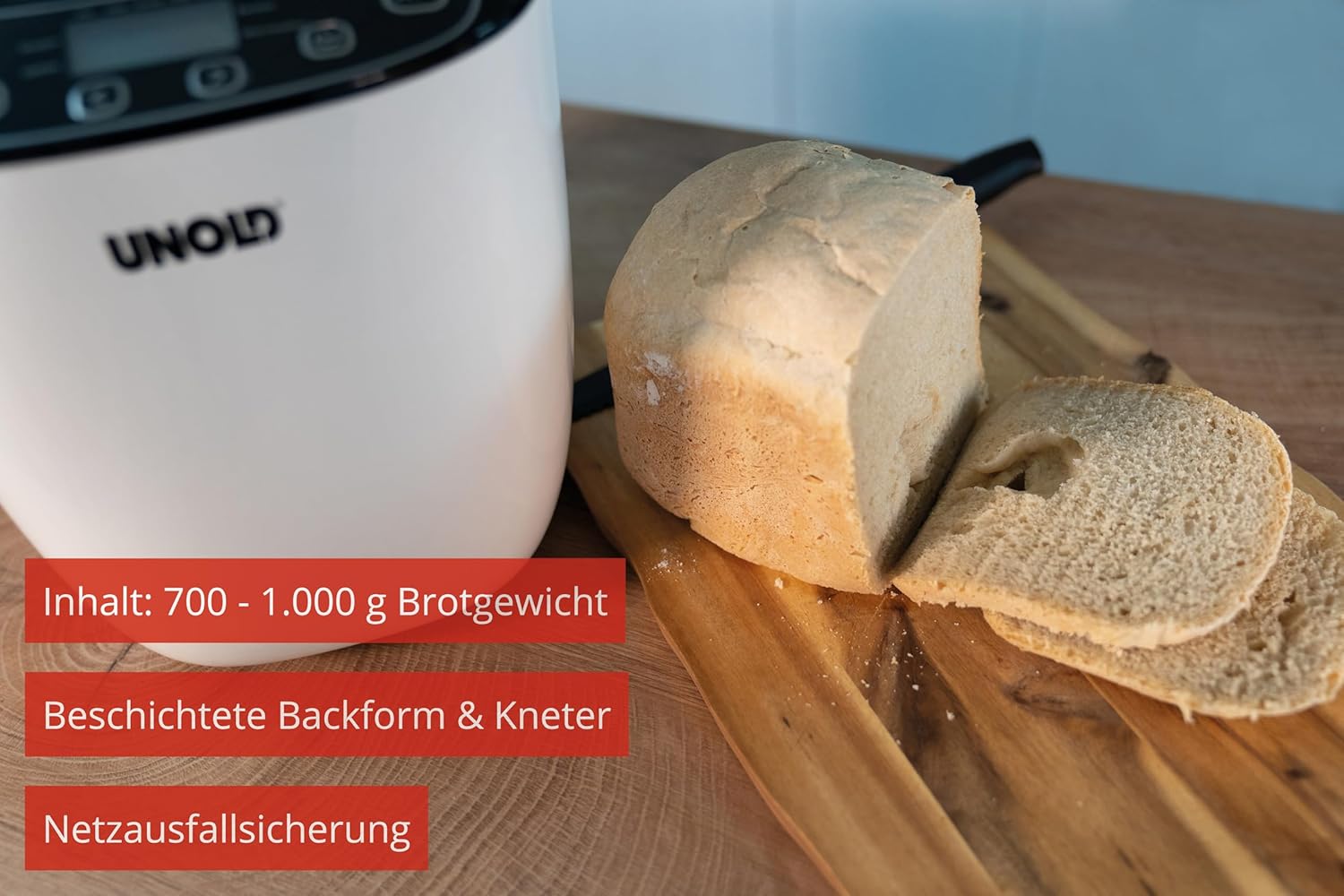 Image of a sliced loaf of bread next to the Unold 68010 bread maker, highlighting its capacity of 700-1000g, coated baking pan and kneading paddle, and power failure protection feature.