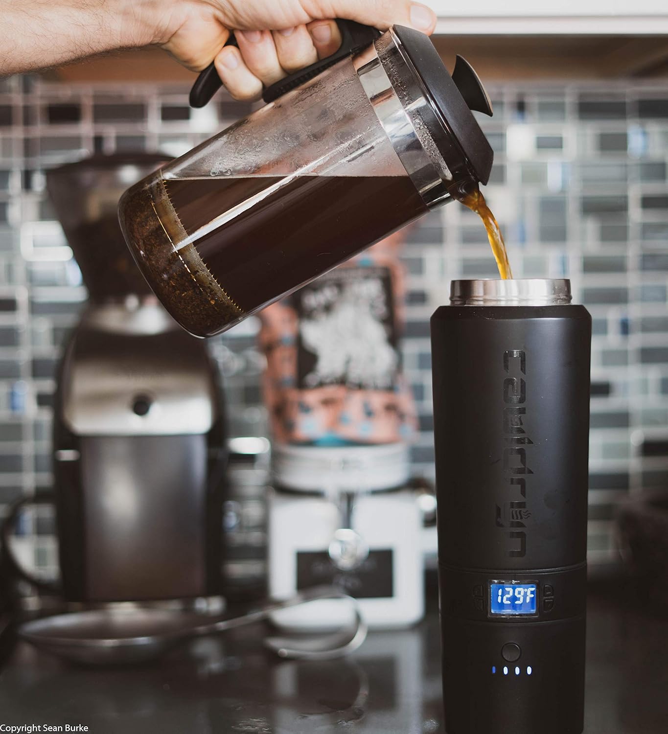 Person pouring coffee from a French press into the Cauldryn Coffee Pro Smart Mug.