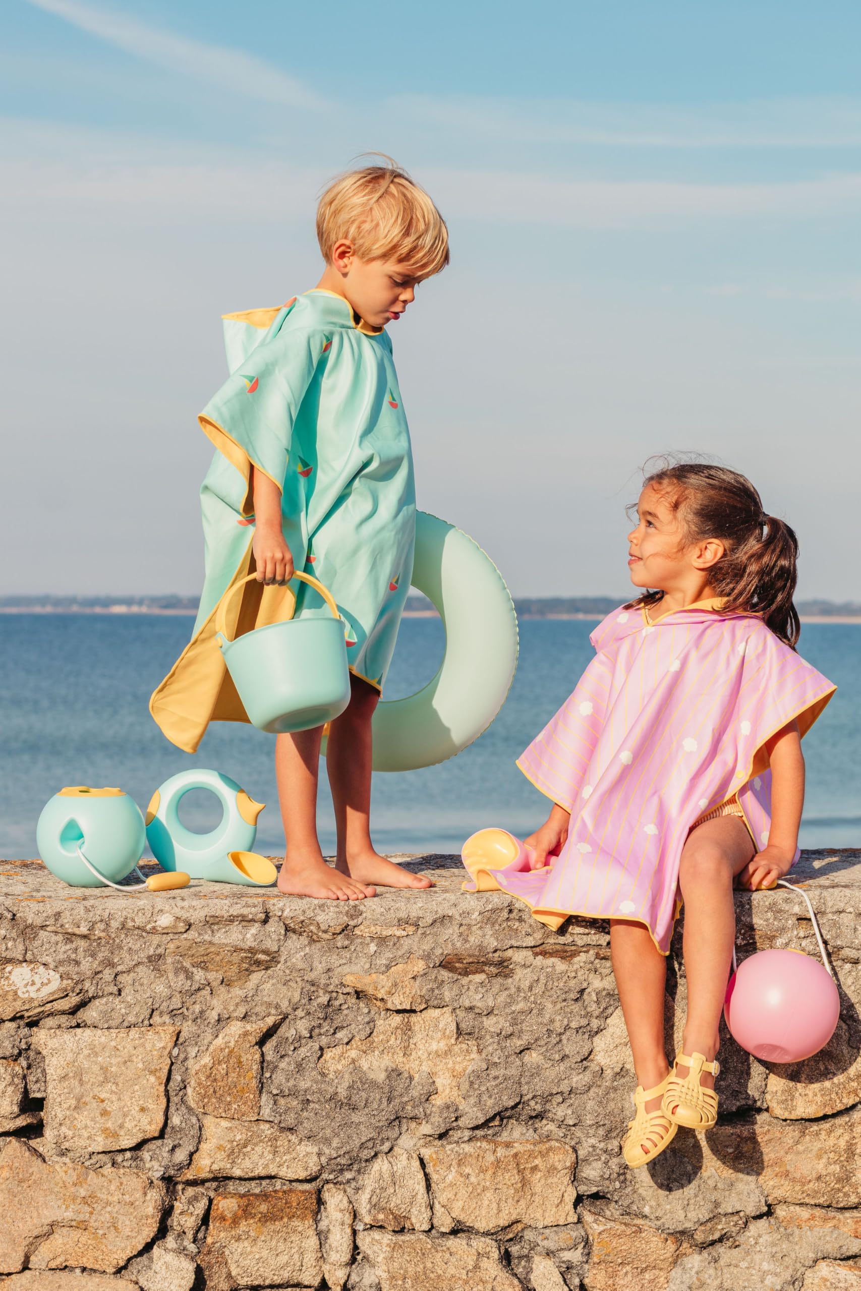 Quut – Poncho spiaggia per bambini rosa banana (conchiglie) – 60 x 60 cm – Microfibra ultra assorbente – Asciugatura rapida – Resistente alla sabbia – Leggero e compatto – Lavabile a 30 °C