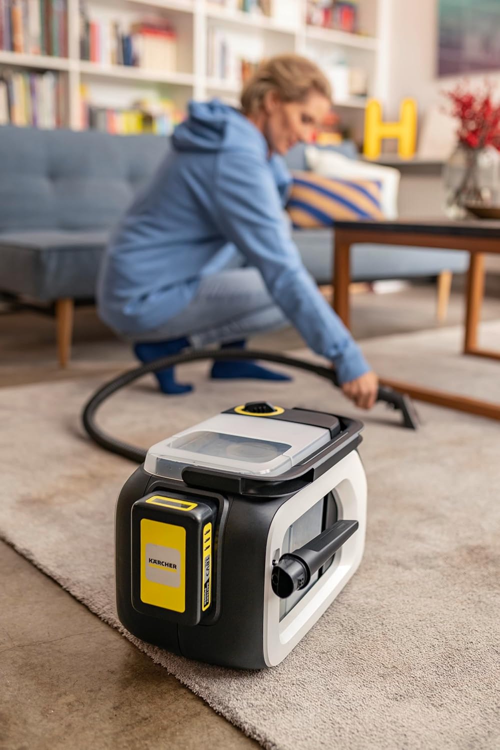 User cleaning car interior carpet with Kärcher SE 3-18 Compact