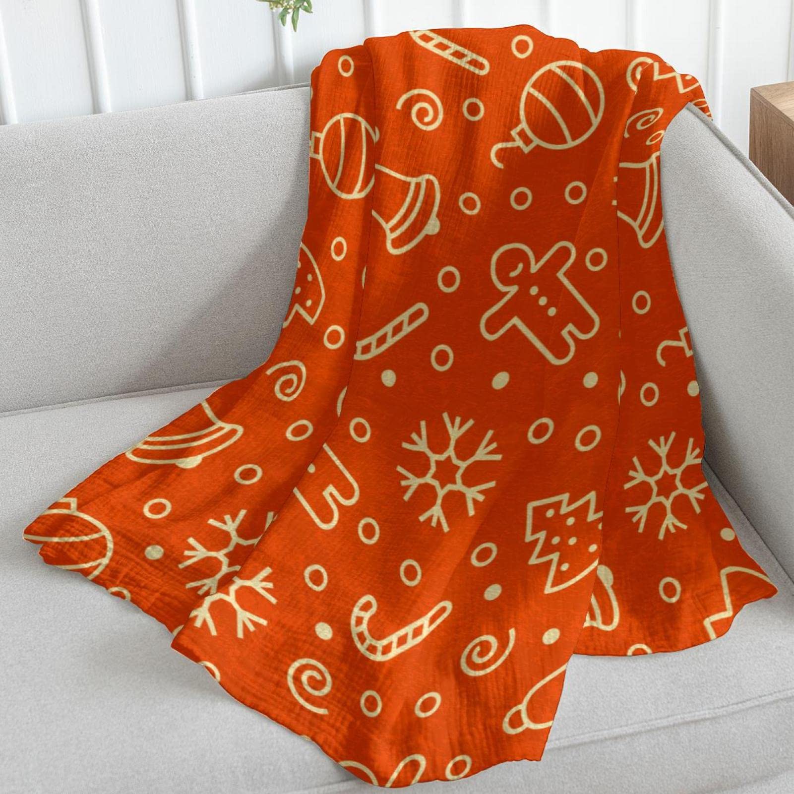 Coperta in pile arancione con elementi natalizi per divano, divano o letto